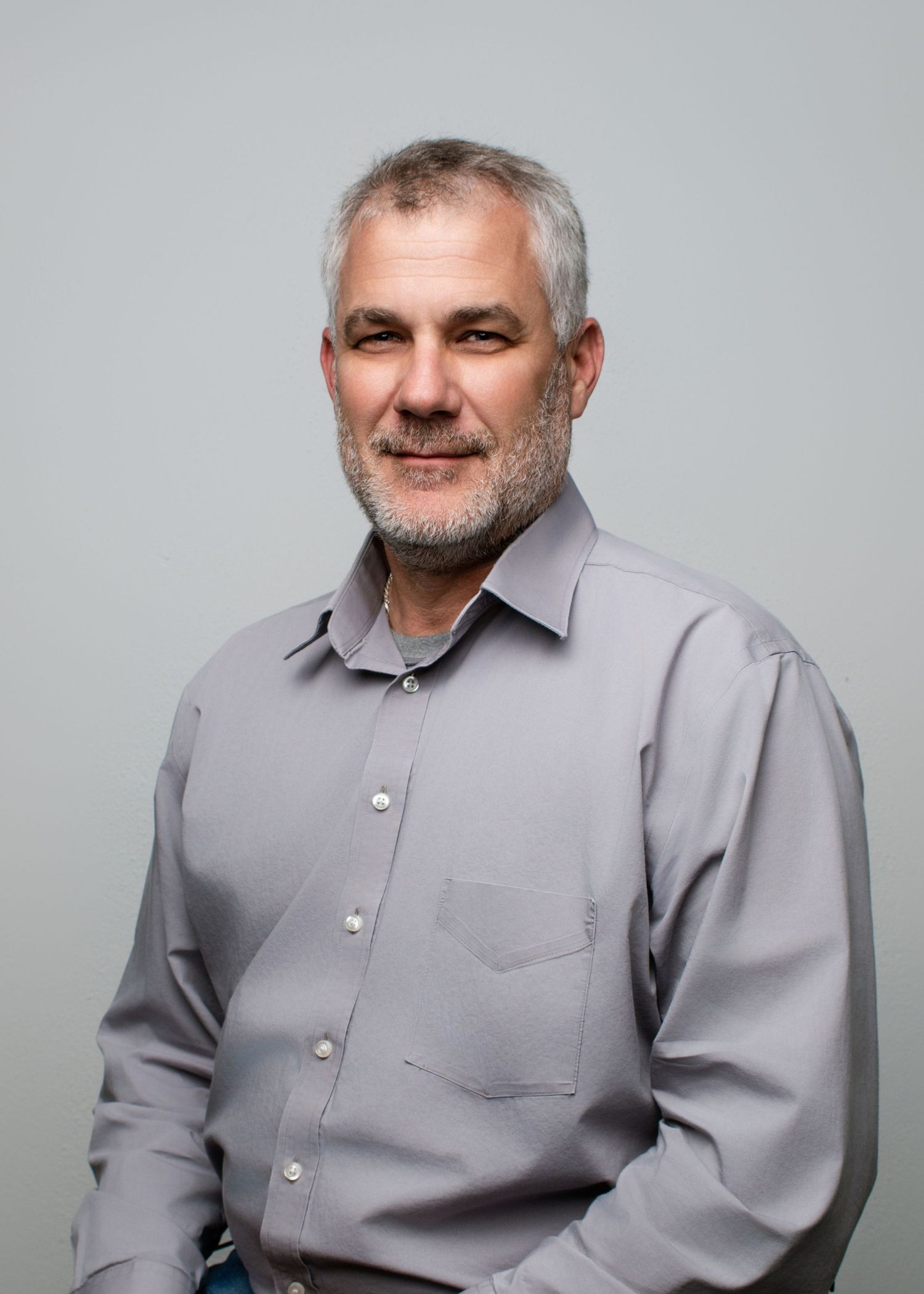 Professional headshots showing someone in a light gray button-up shirt.