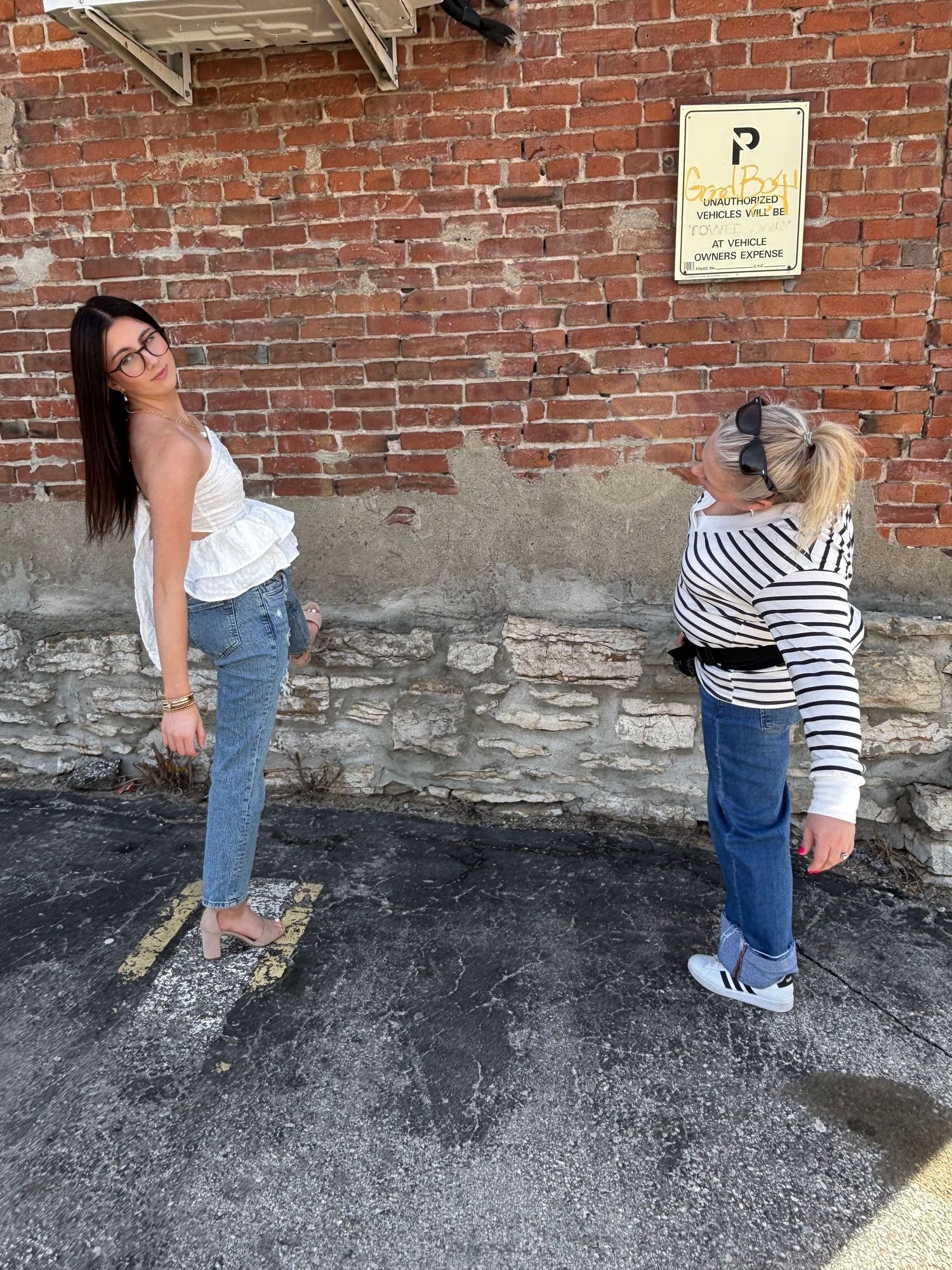 A person in jeans and striped shirt demonstrates a sequence of stretching poses against a brick wall.