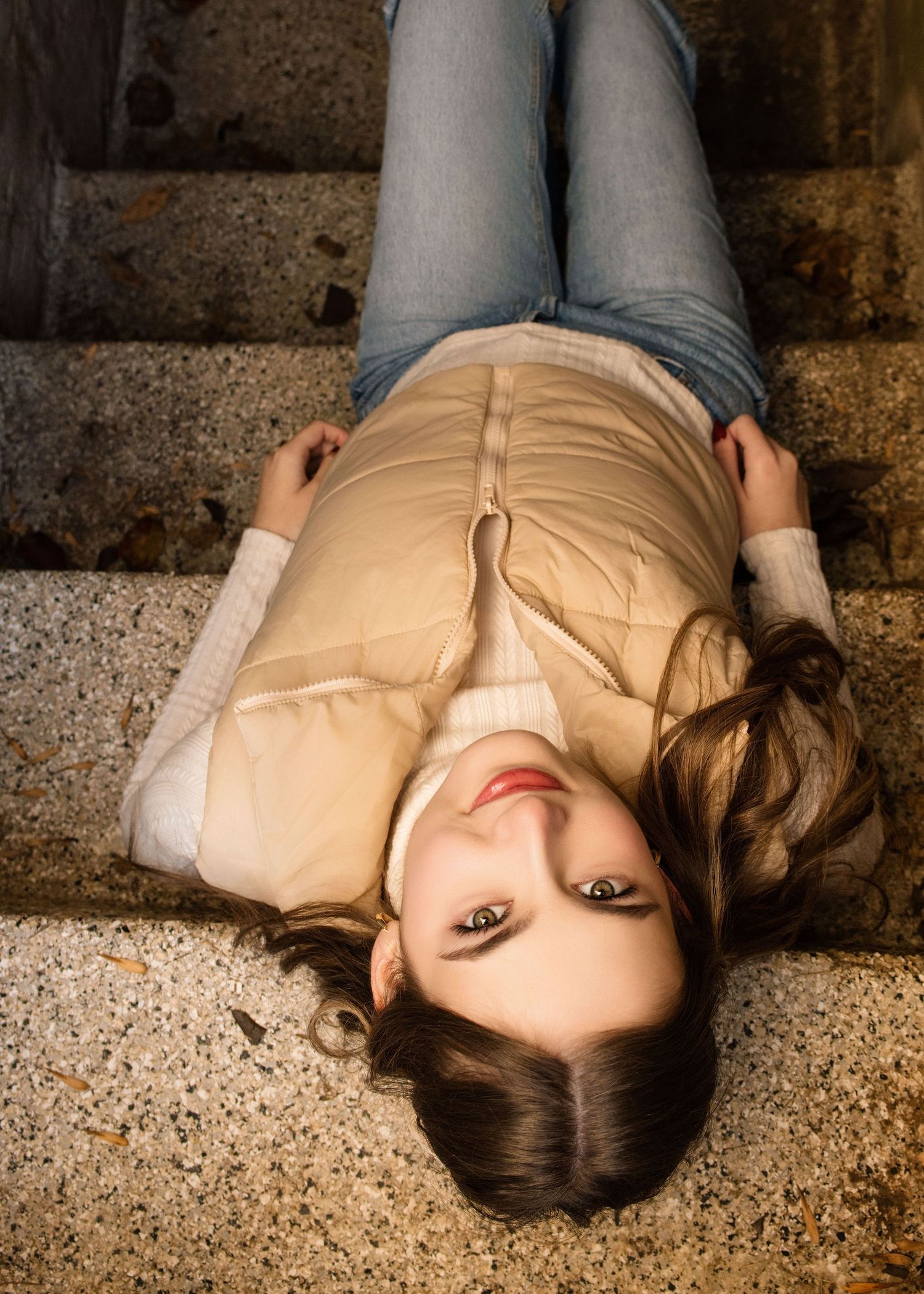 Artistic portrait on textured concrete floor in casual beige outfit.