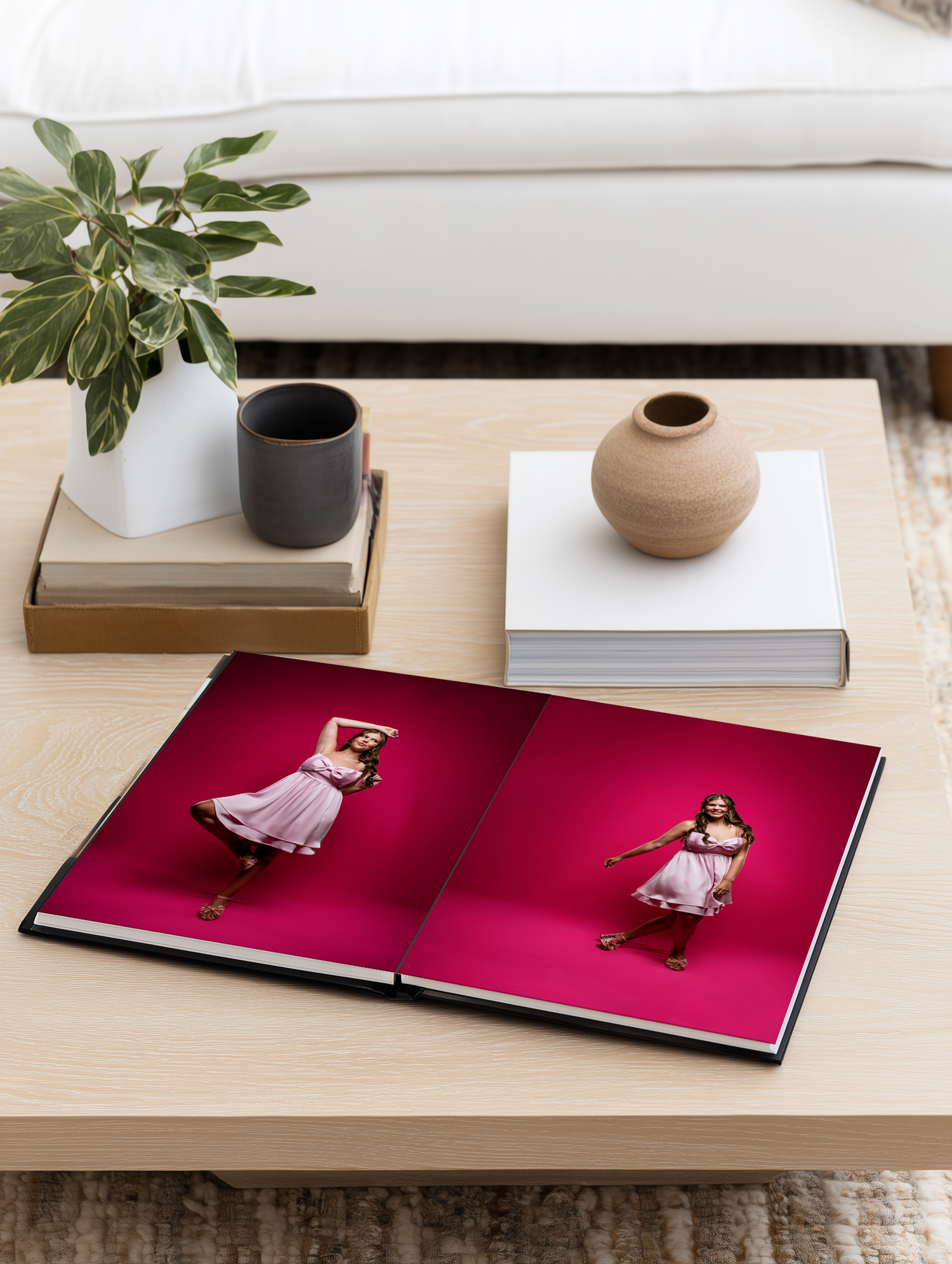 A series of images showing a photo book with pink pages displayed on a wooden surface with decorative objects.