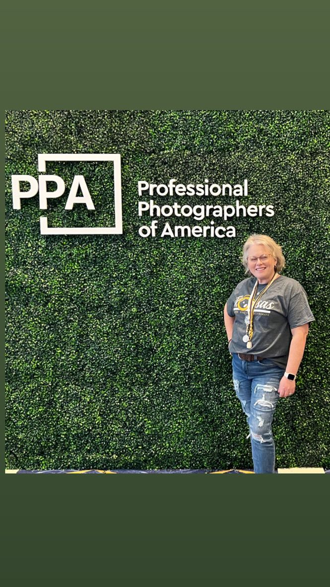 Three photographers pose in front of a green hedge wall with Professional Photographers of America PPA branding.
