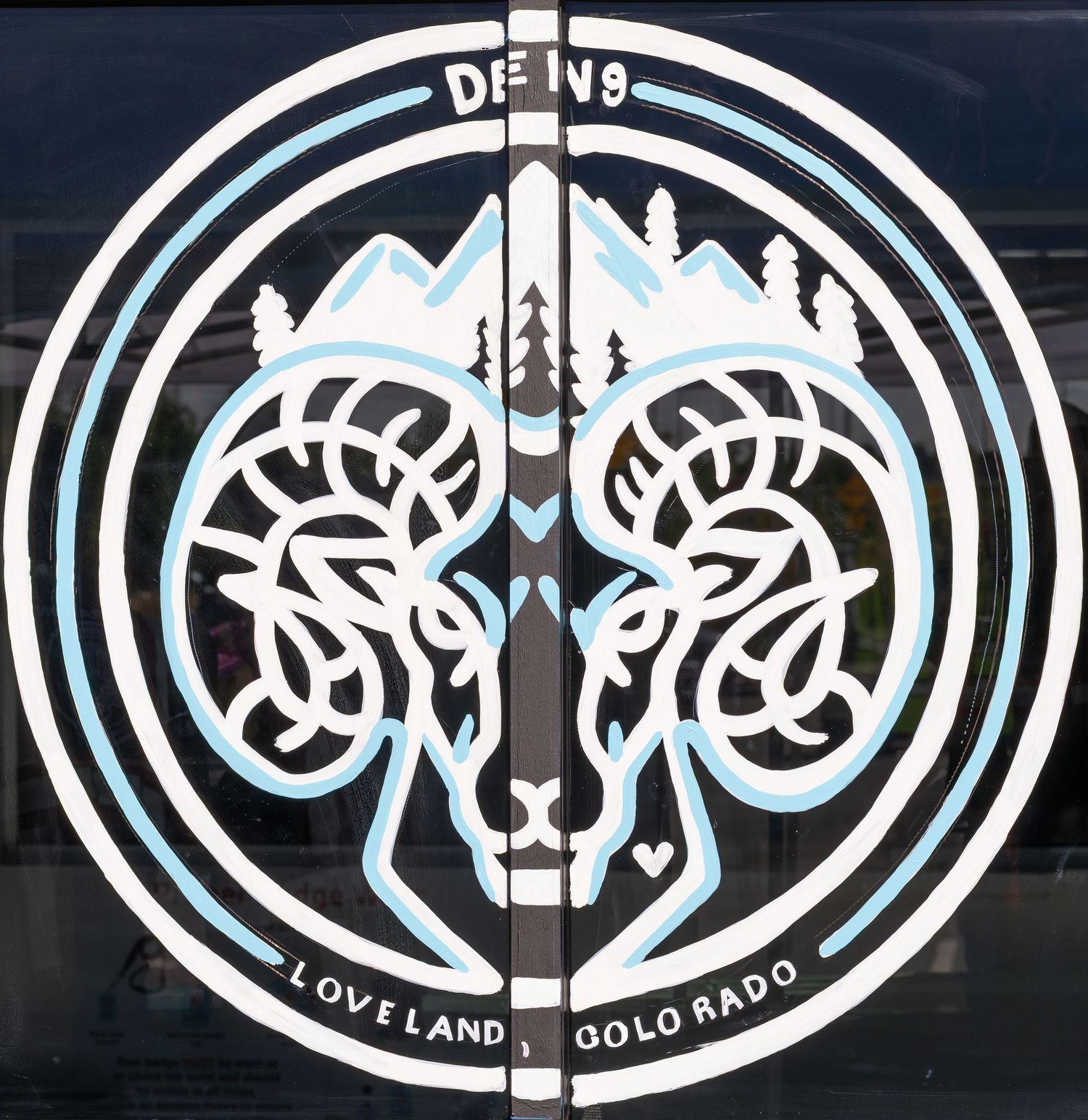 Circular logo for DFNS featuring twin rams, mountains, trees, and text reading Loveland Colorado in black and blue.
