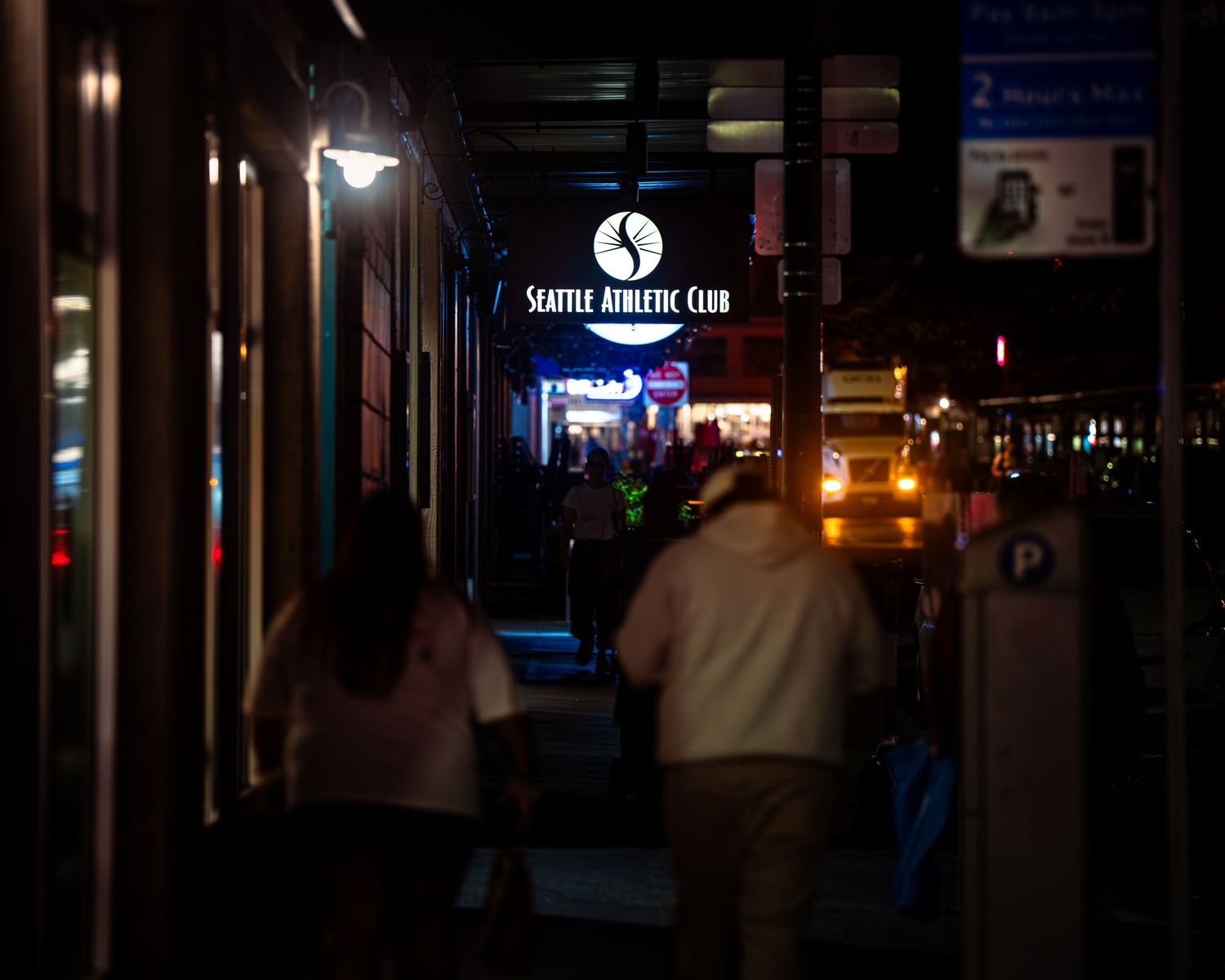 Dark corridor with distant lights and signage creating moody urban atmosphere.