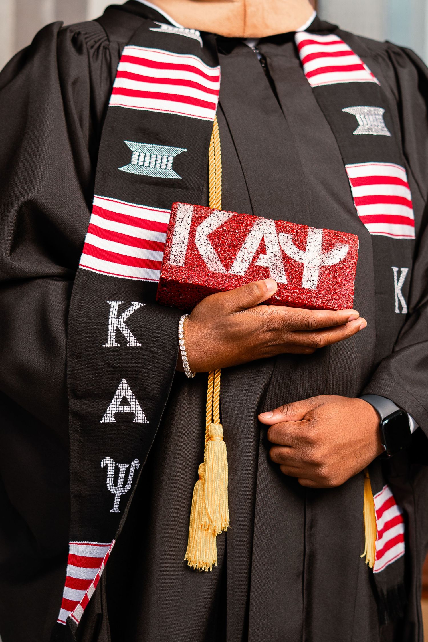 Close-up of Kappa Alpha Psi fraternity graduation stole and bedazzled cap.