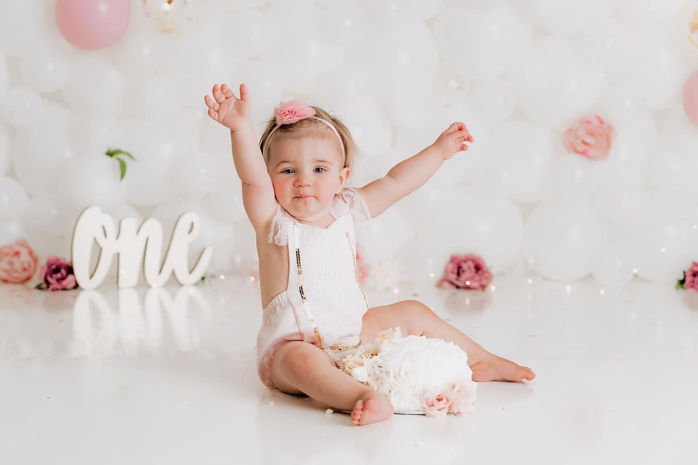 One-year-old celebrating a first birthday cake smash session in studio