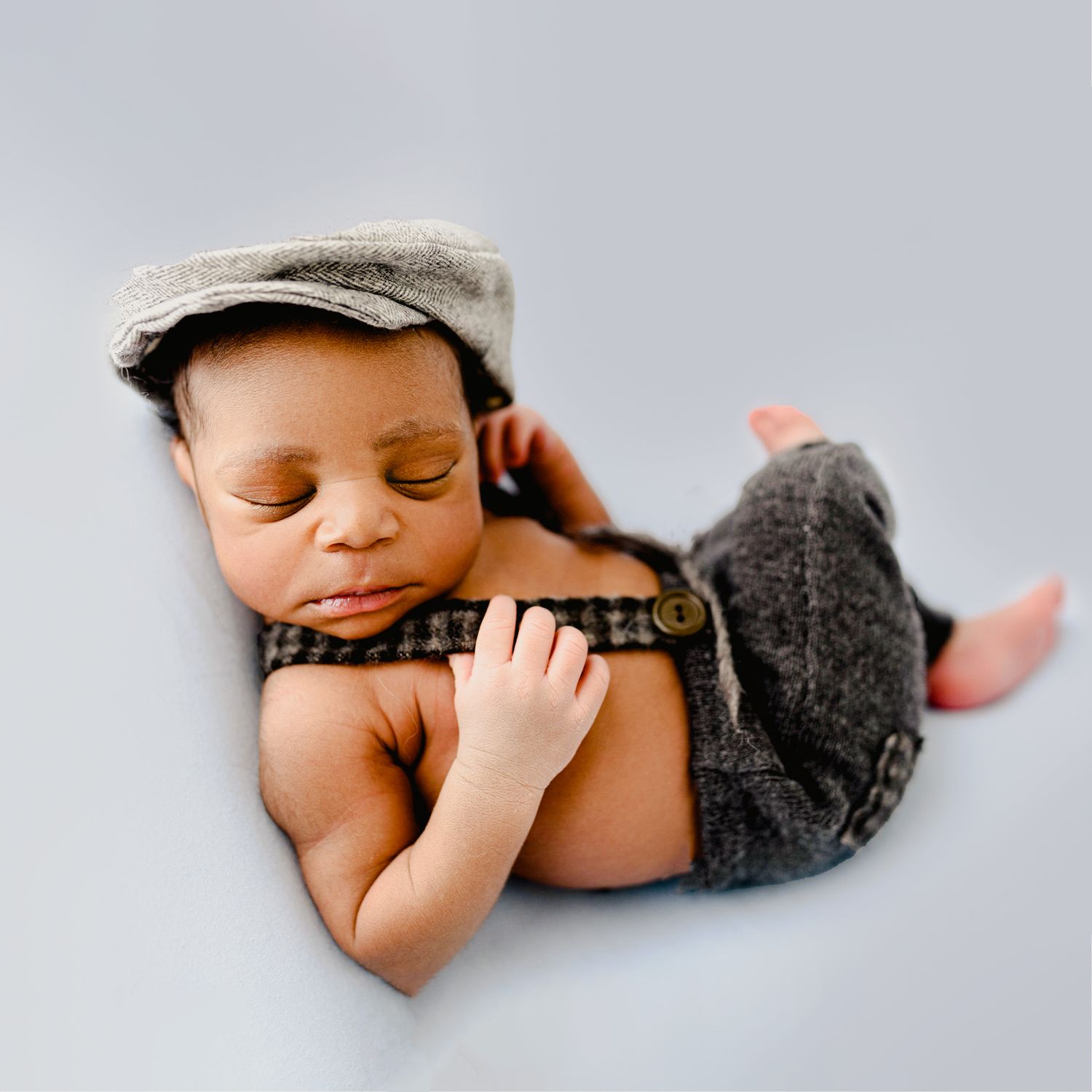 Newborn baby wearing a knit hat and wrapped snugly in a studio newborn portrait