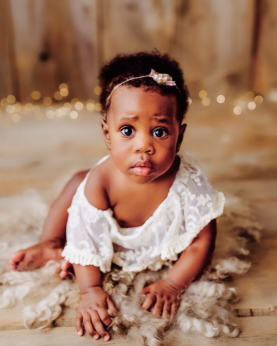 Baby milestone portrait capturing natural expression in a neutral studio setting