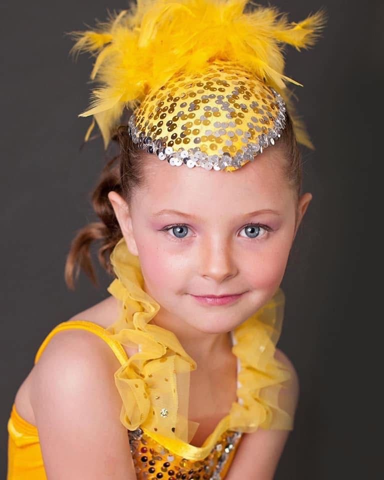 toddler in a chicken dance costume, studio portrait