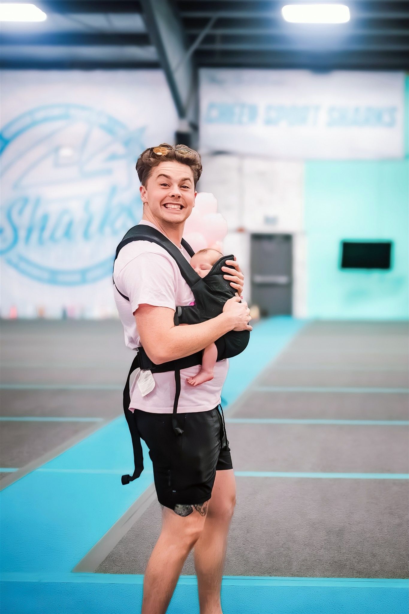 coach with baby inside cheer gym