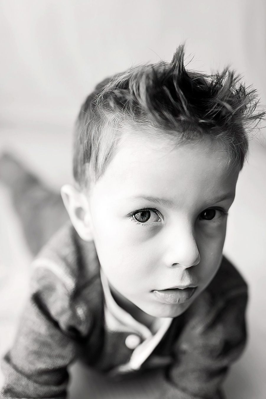 Black and white close-up portrait of a young toddler boy with a serious expression