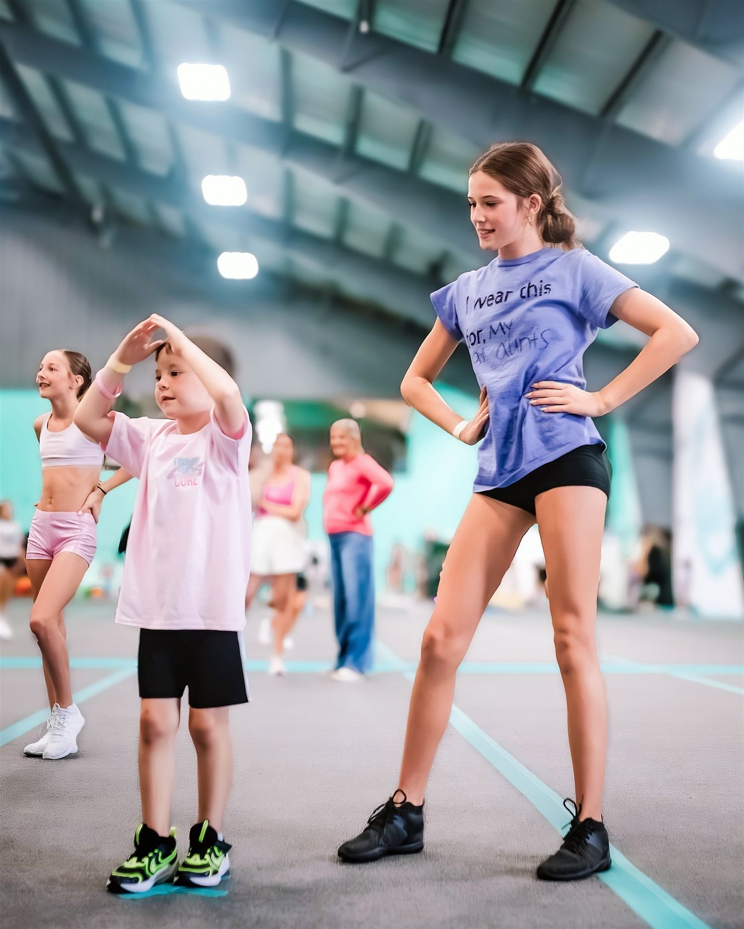 youth cheerleadier leading a group of young athletes in a bright gym setting