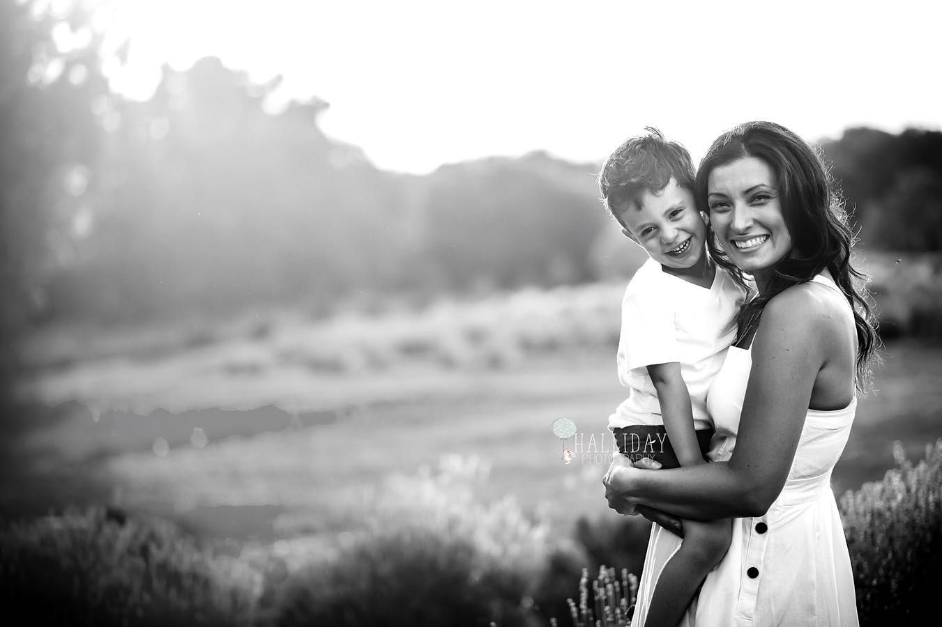 mother and son posing in a black and white image at sunset