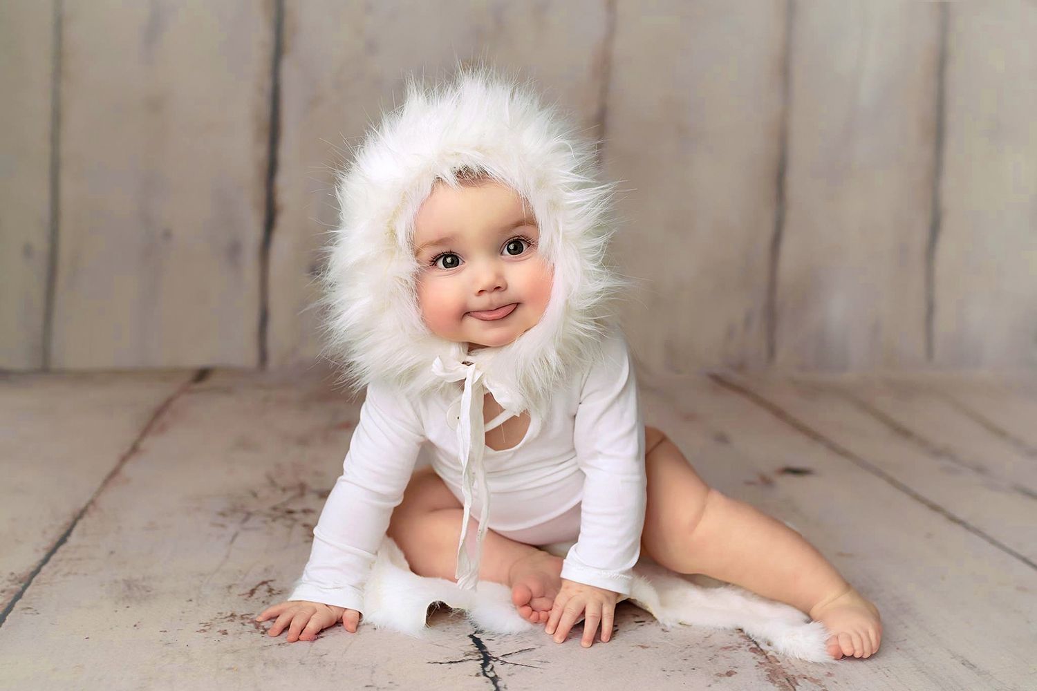 Baby milestone portrait photographed in studio with a neutral wooden backdrop