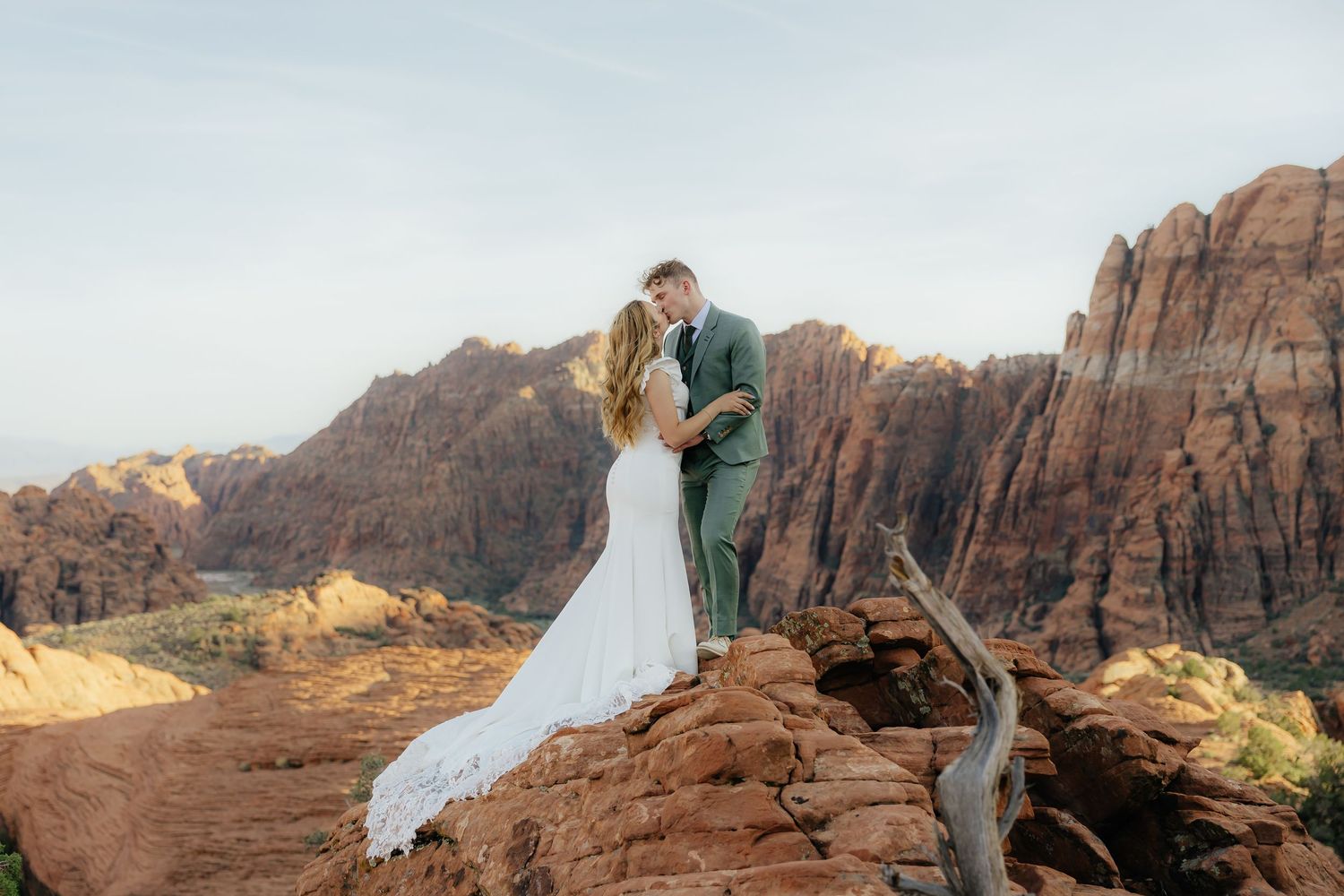 Couple sharing a kiss overlooking the St. George red rock valley during a classy bridal summer bridal session.