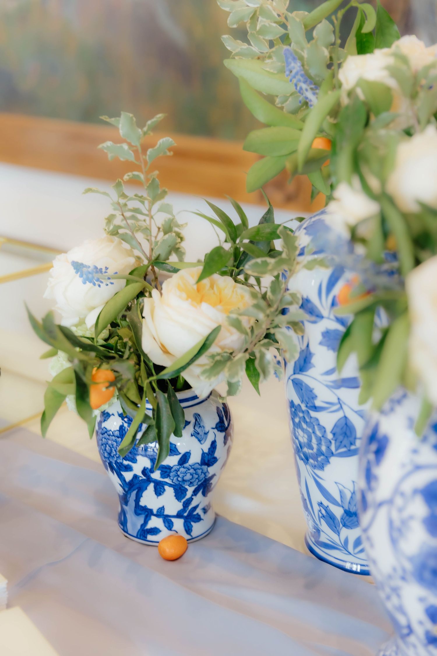 Luxury decor of blue and white floral arrangements styled in ceramic vases at a wedding reception