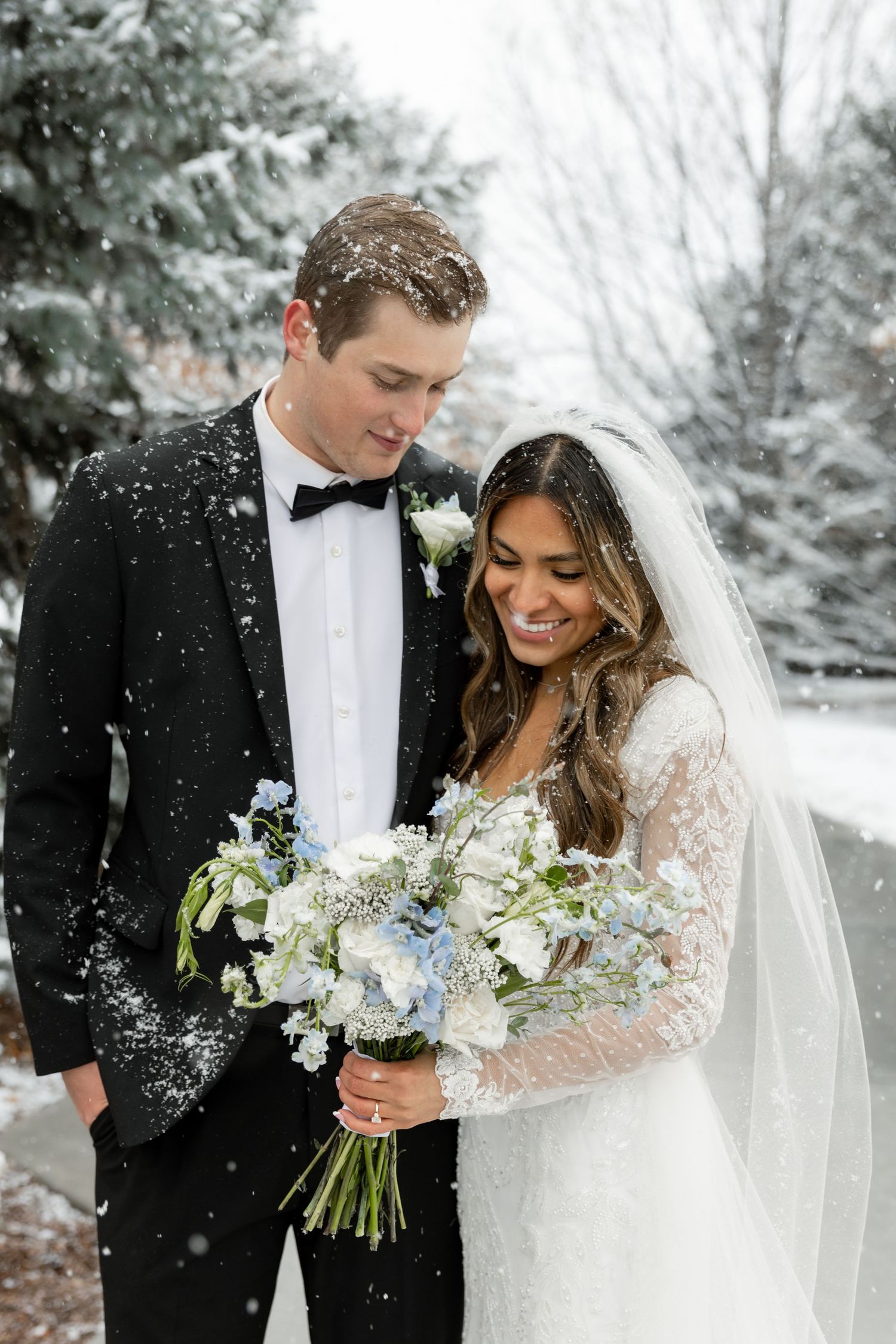 Couple smiling during winter snowy wedding photography session