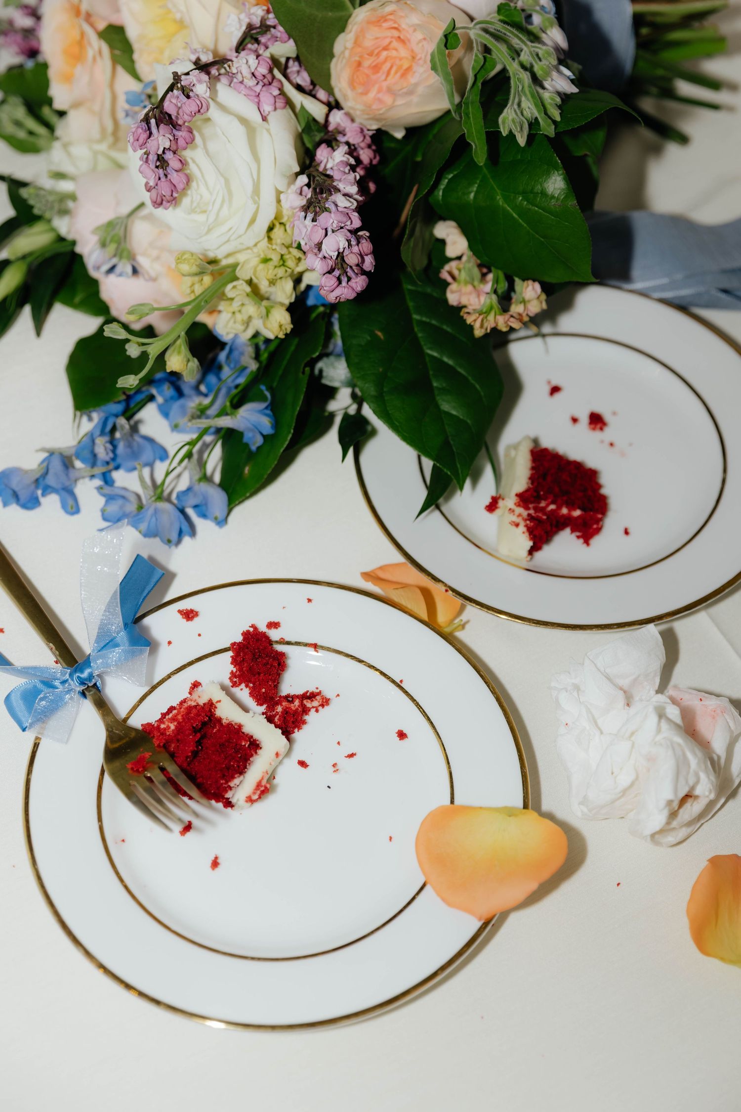 Editorial dessert flat lay with plated cake and florals at a wedding reception
