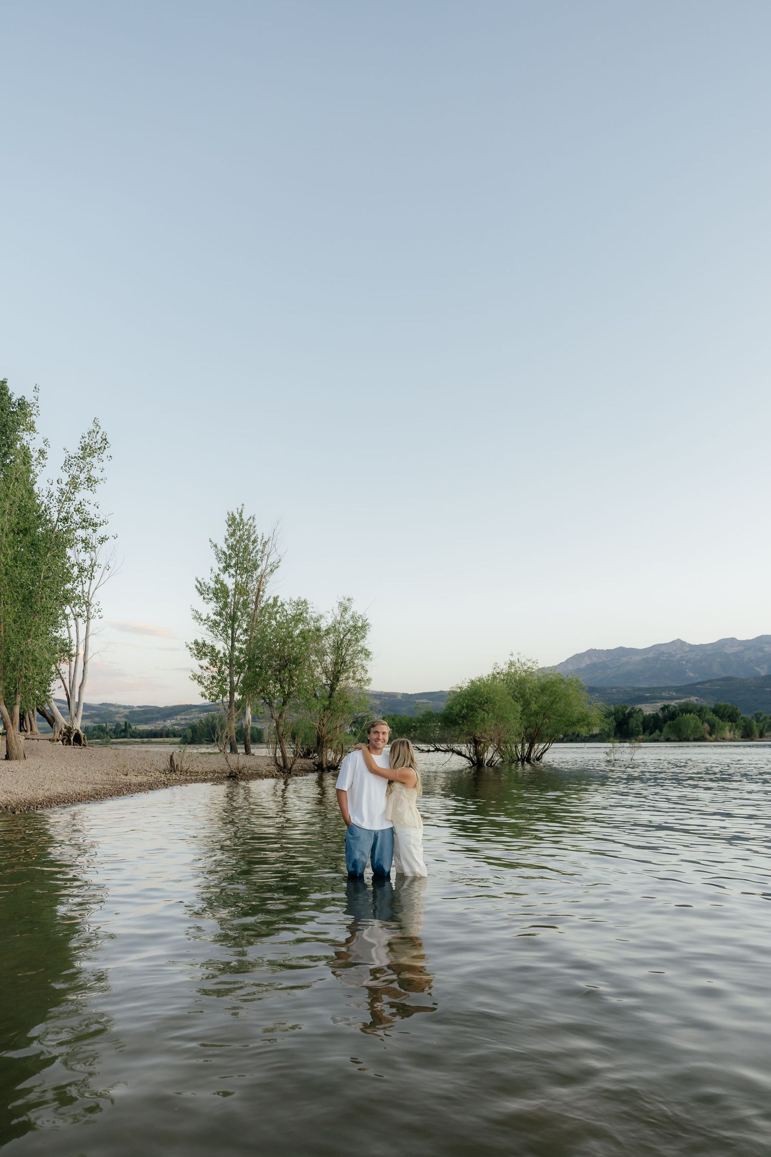 Couple embracing by a lake during a romantic Utah wedding portrait session