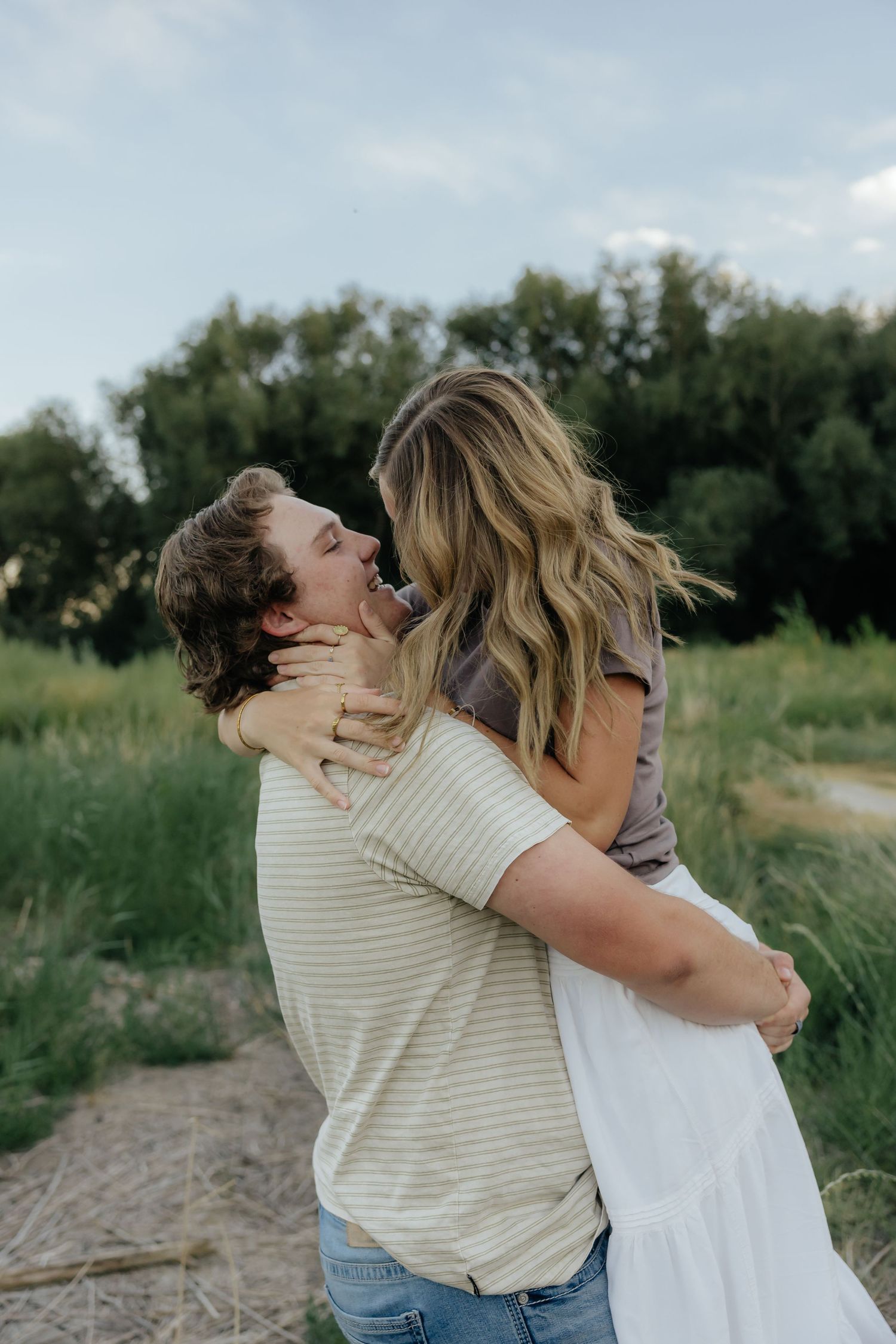 Couple laughing together during a casual summer engagement photo session