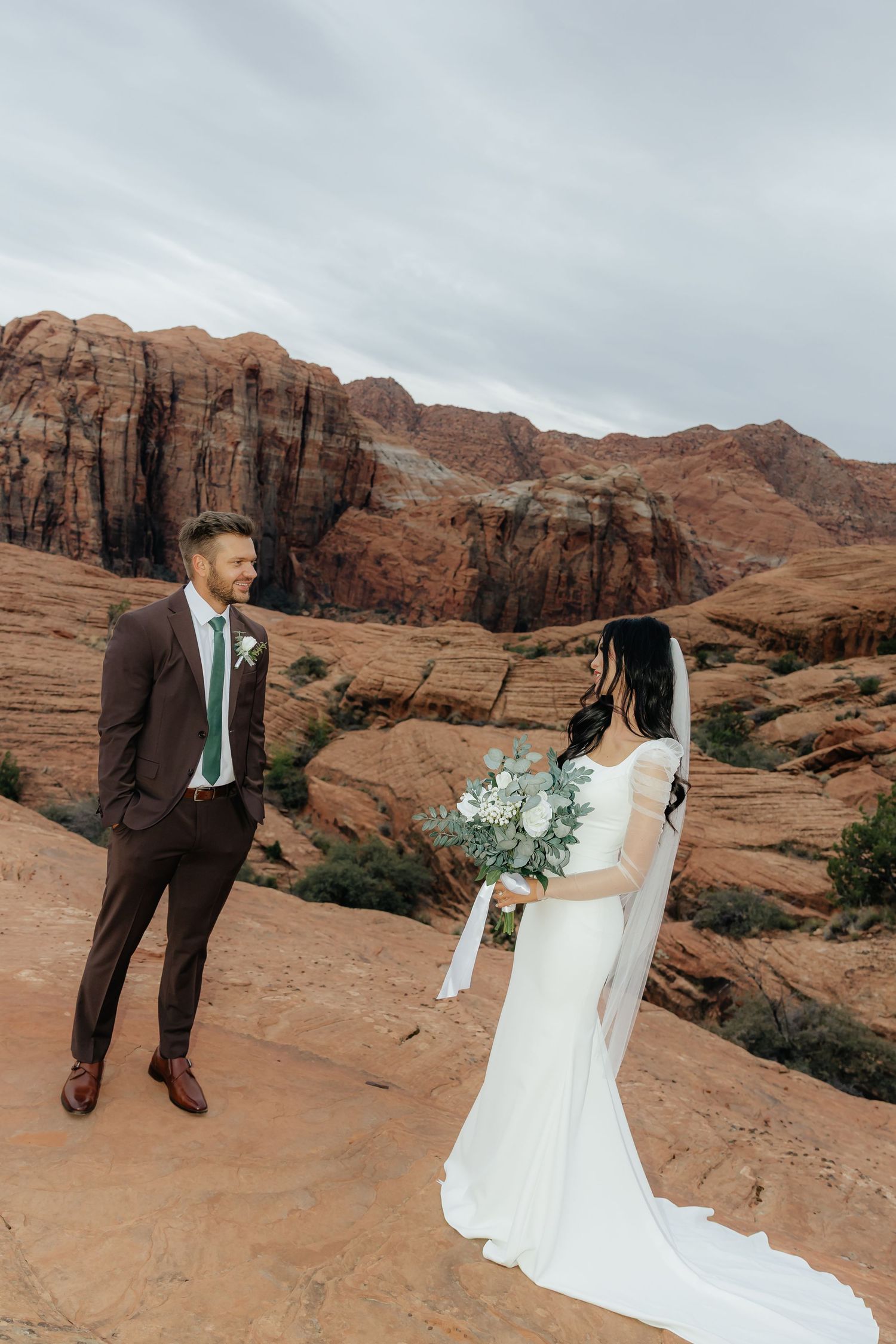 Bride and groom posing during an elegant bridal portrait session in St. George Utah, red rocks.