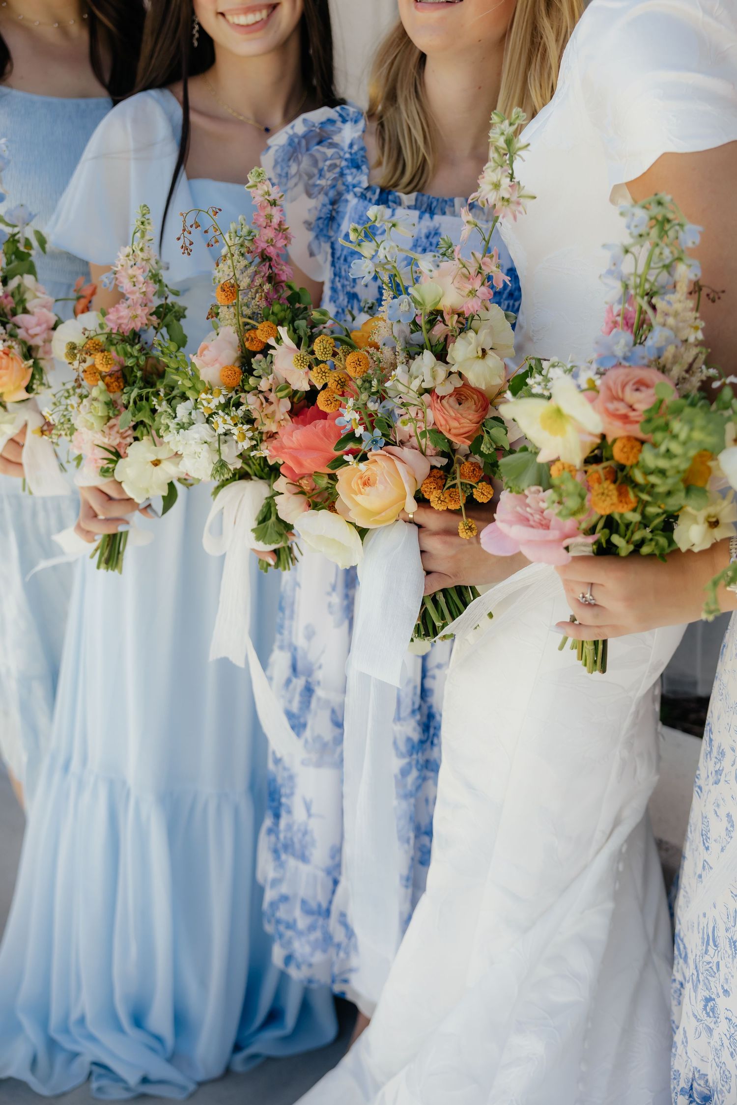 Bridesmaids holding colorful floral bouquets for a spring wedding in Idaho.