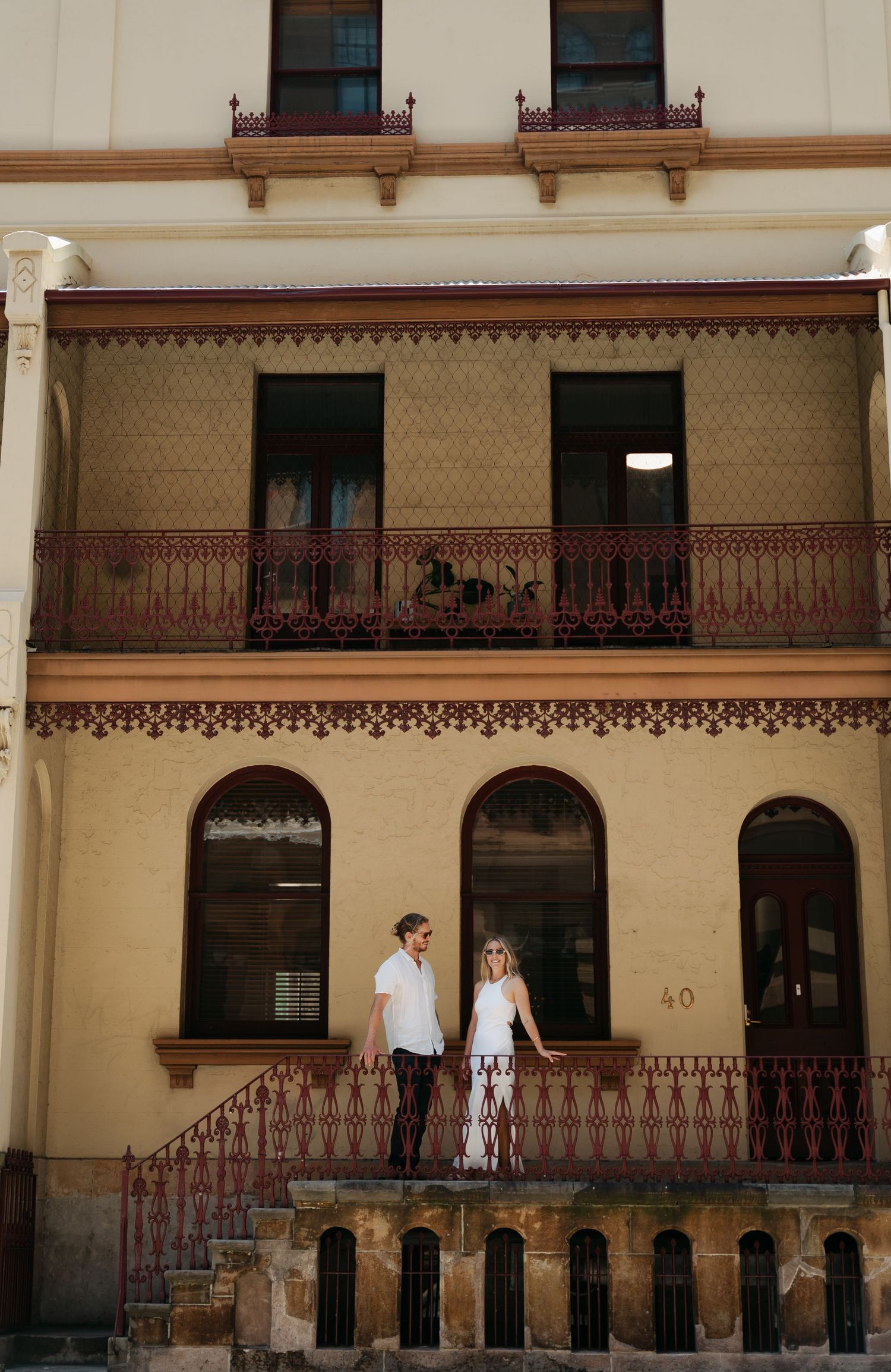 Architectural details of a historic building facade with arched doorways, balconies, and ornate wooden railings.