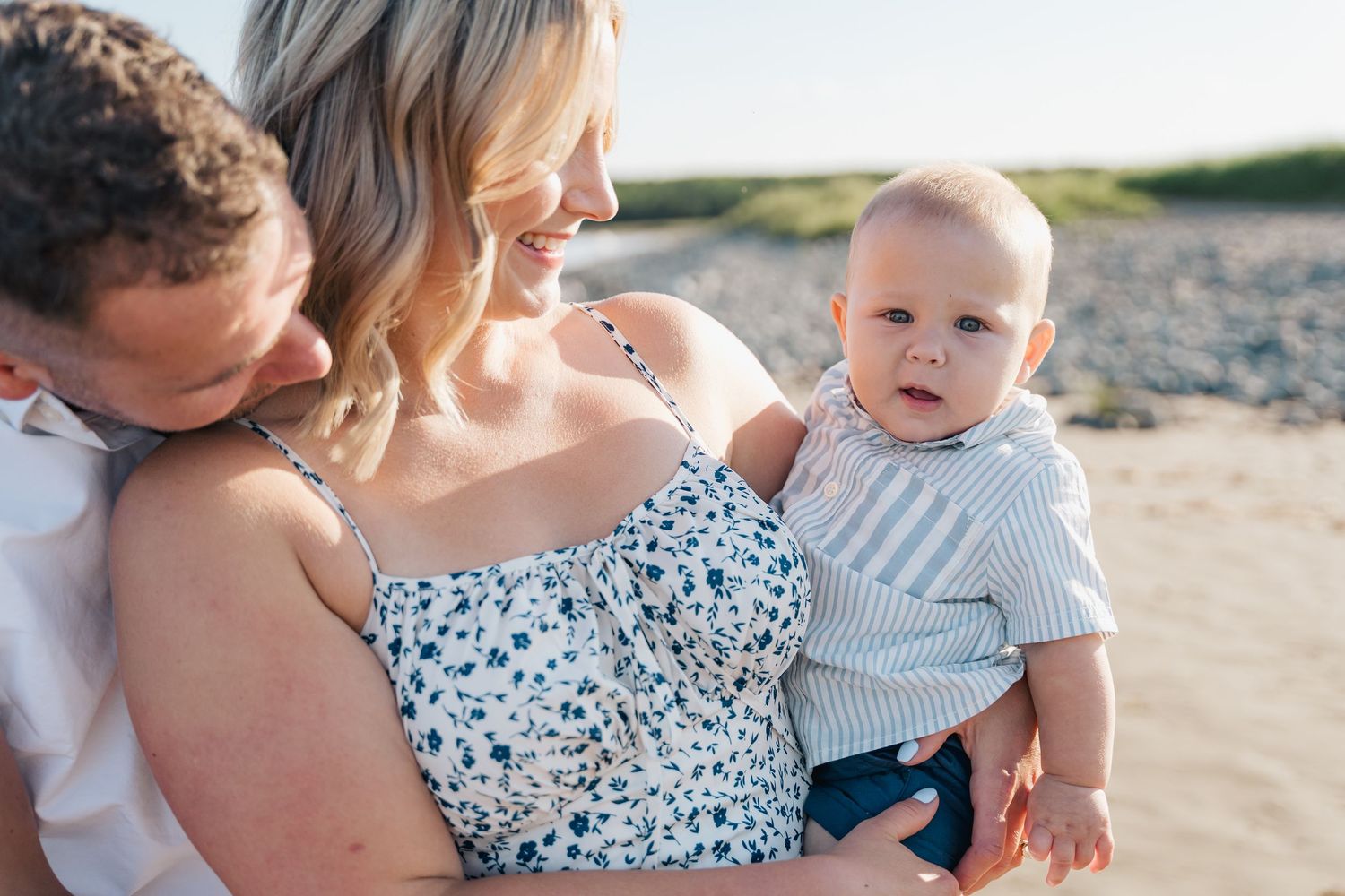 A series of candid beach photos showing tender family moments at sunset with a baby and adults in casual summer attire in Halifax, NS.