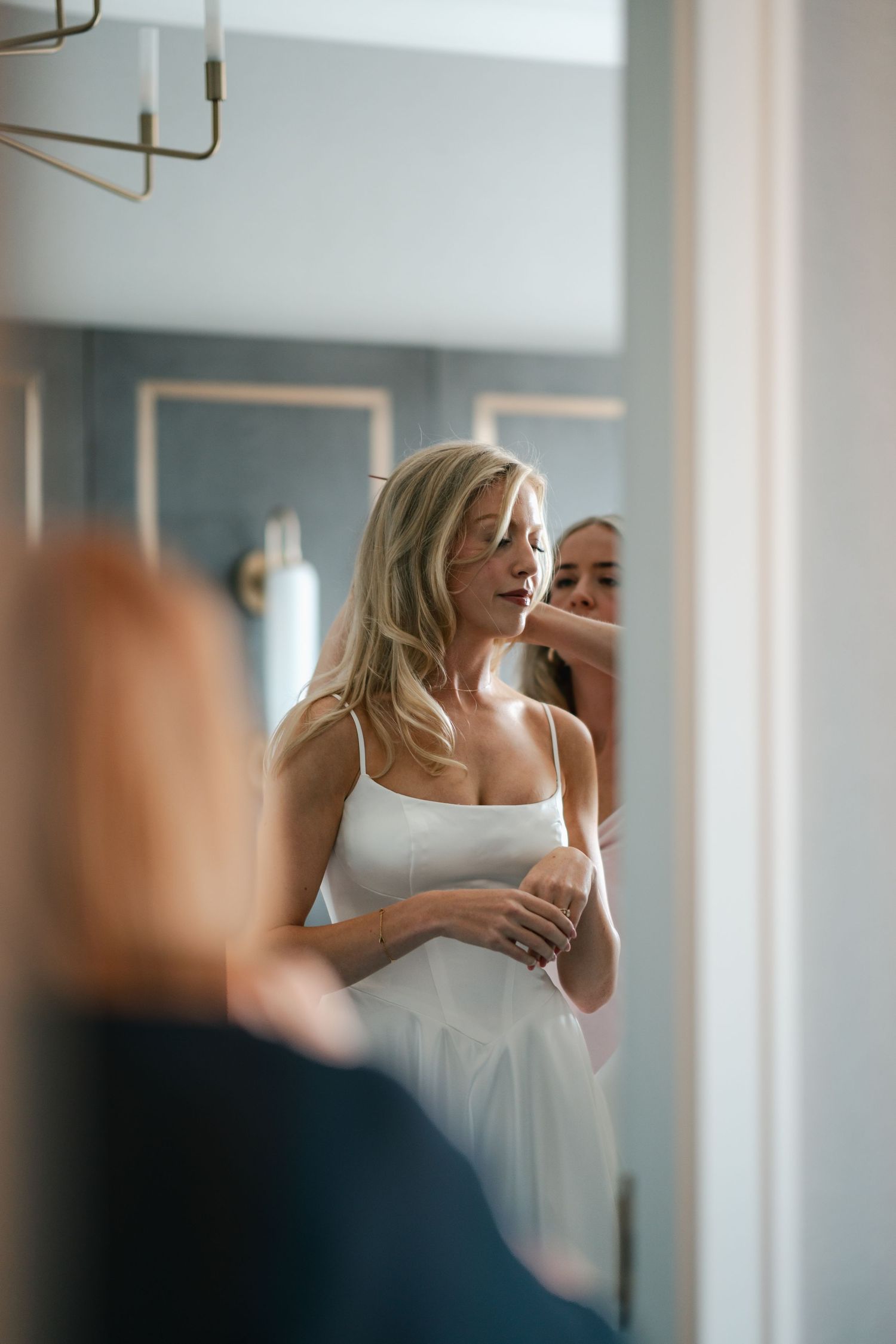 A bride getting ready in front of a mirror on her wedding day in Halifax, Nova Scotia.