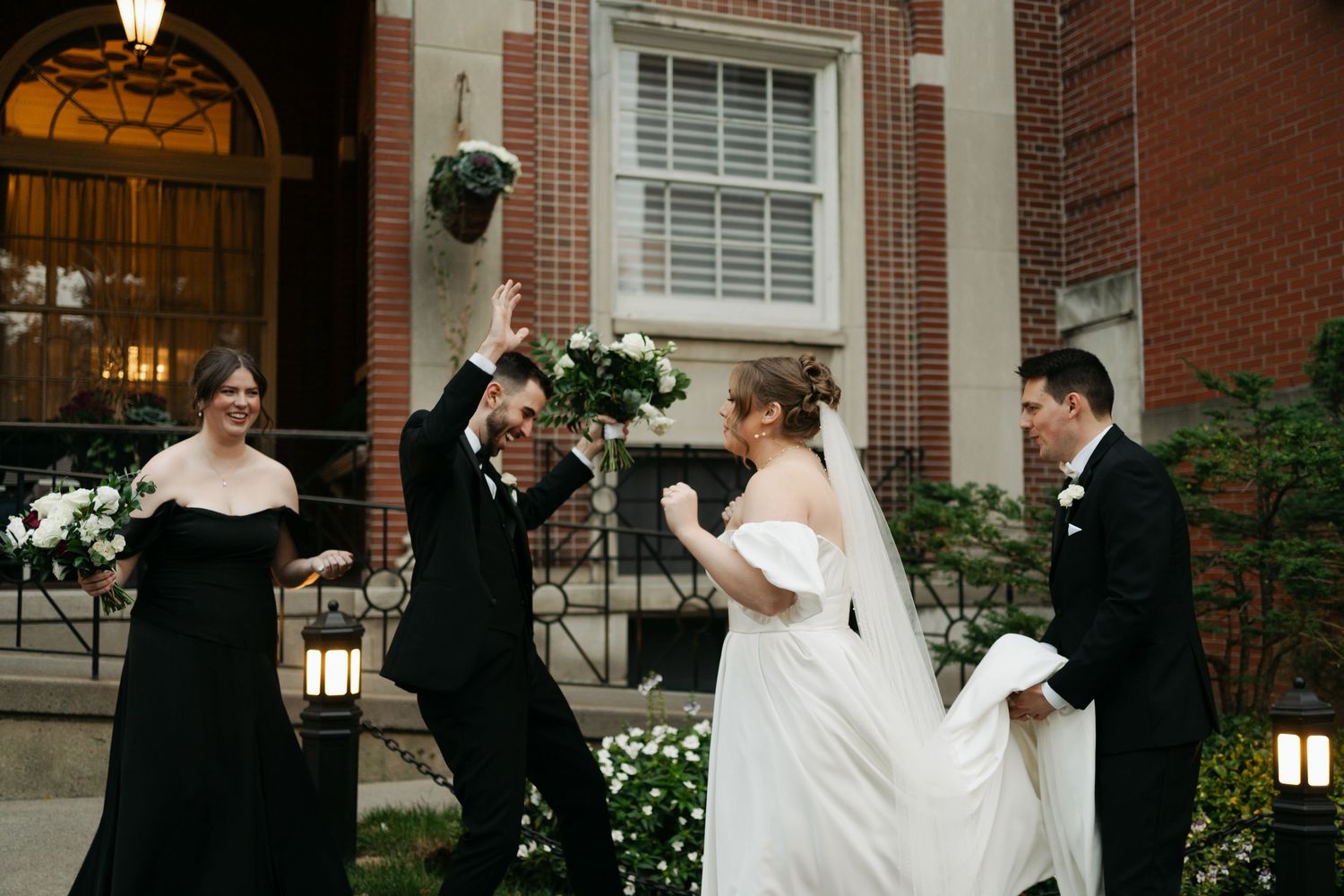 A bride and groom share a romantic dance sequence outside a brick building with elegant lamp at Lord Nelson Hotel, Halifax, Nova Scotia