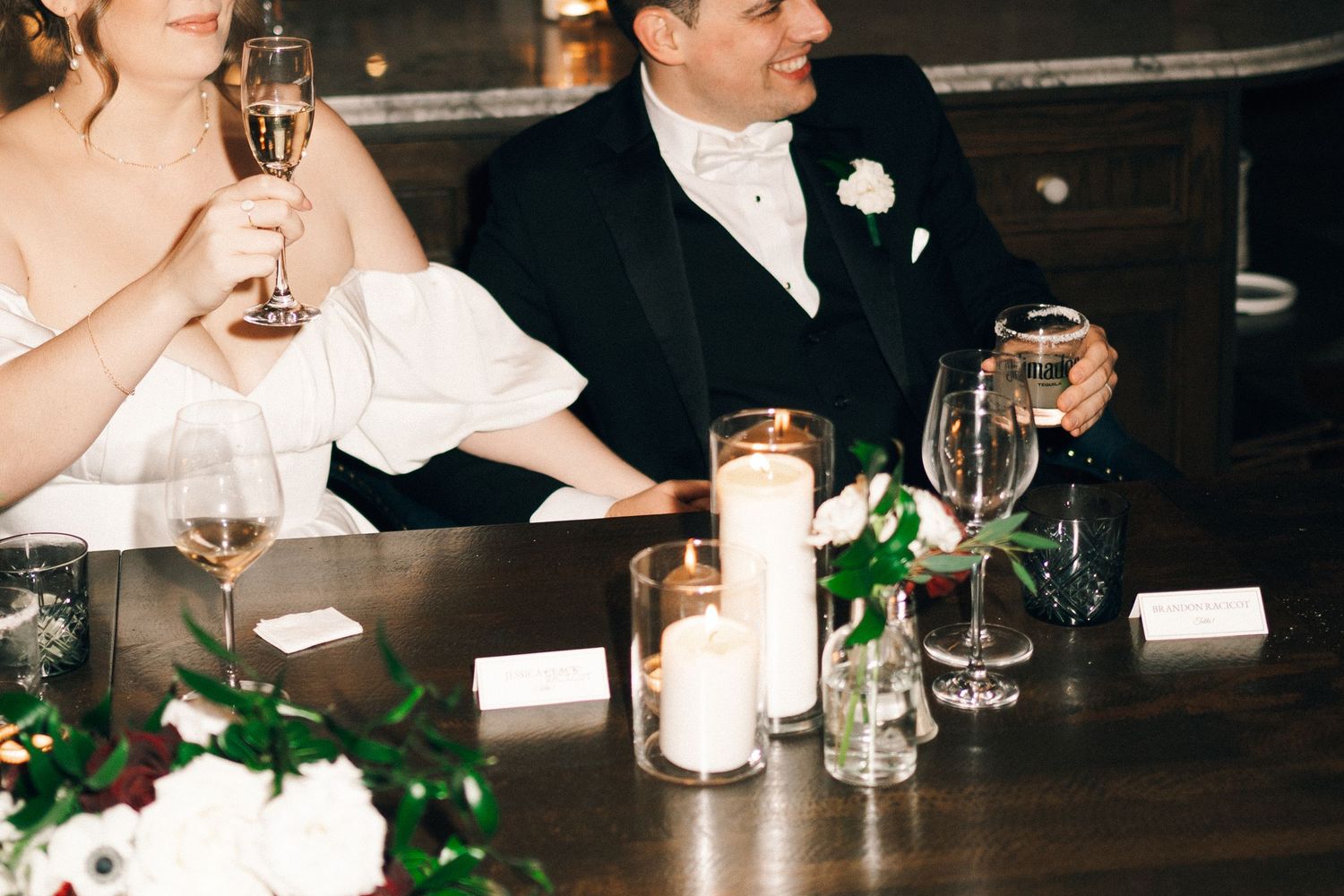 Guests at an elegant wedding reception toast with champagne glasses at a dimly lit bar at Lord Nelson Hotel, Halifax, Nova Scotia.