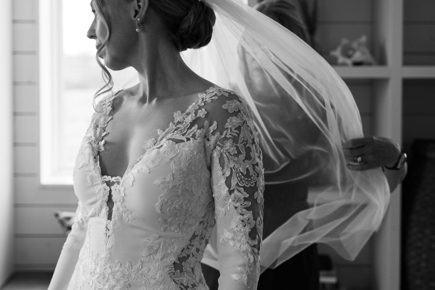 A collection of wedding dress details showing delicate lace sleeves and flowing white veils in natural light at Lightfoot & Wolfville.