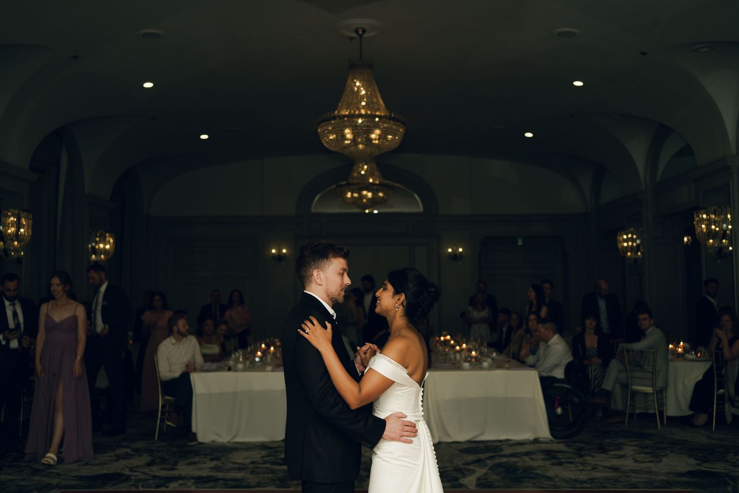 Couple dancing together at an elegant wedding reception with soft lighting and decorative elements in the background in Halifax, Nova Scotia