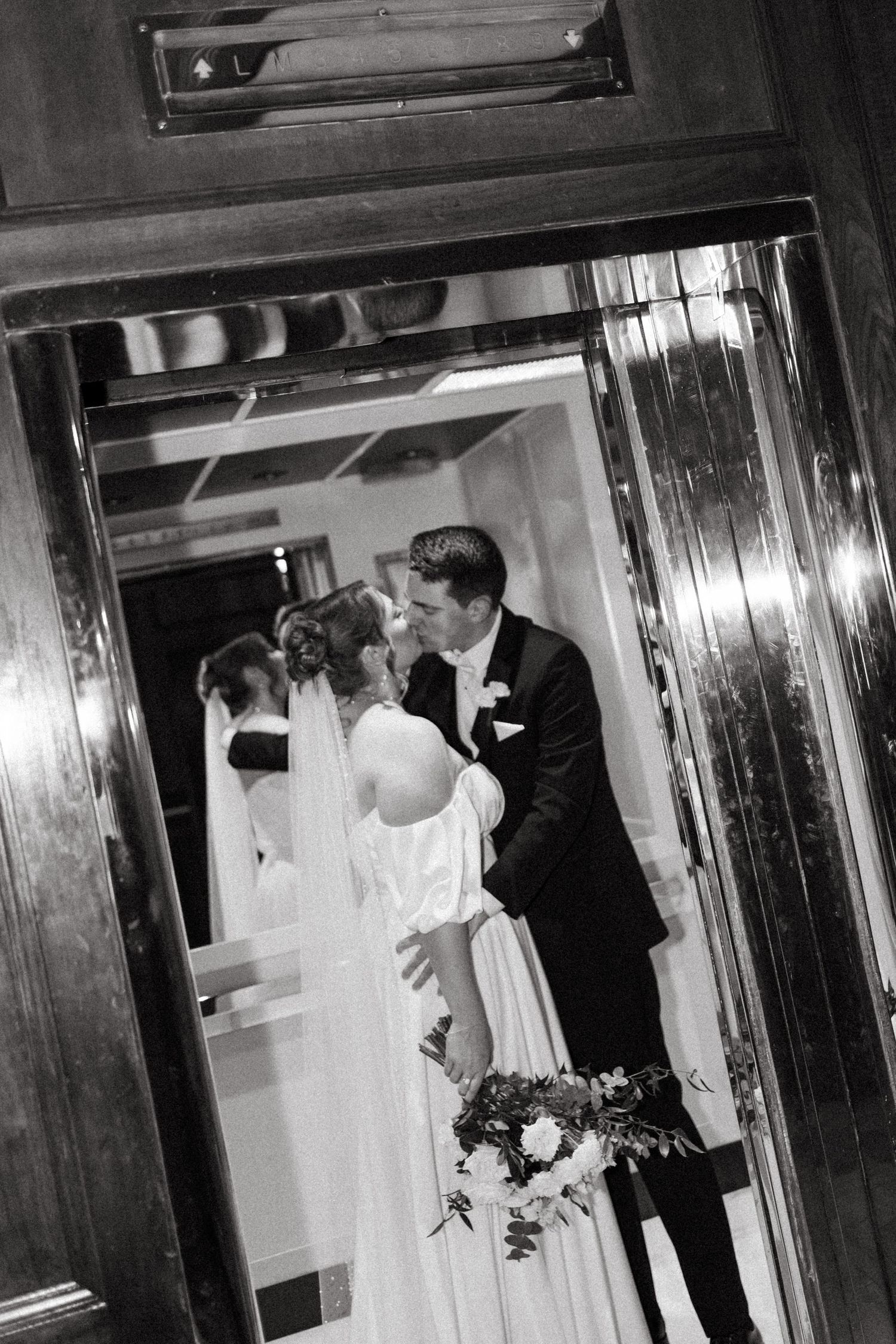 Black and white wedding photographs capture couple's intimate moments in mirrored hallway at Lord Nelson Hotel, Halifax, Nova Scotia.