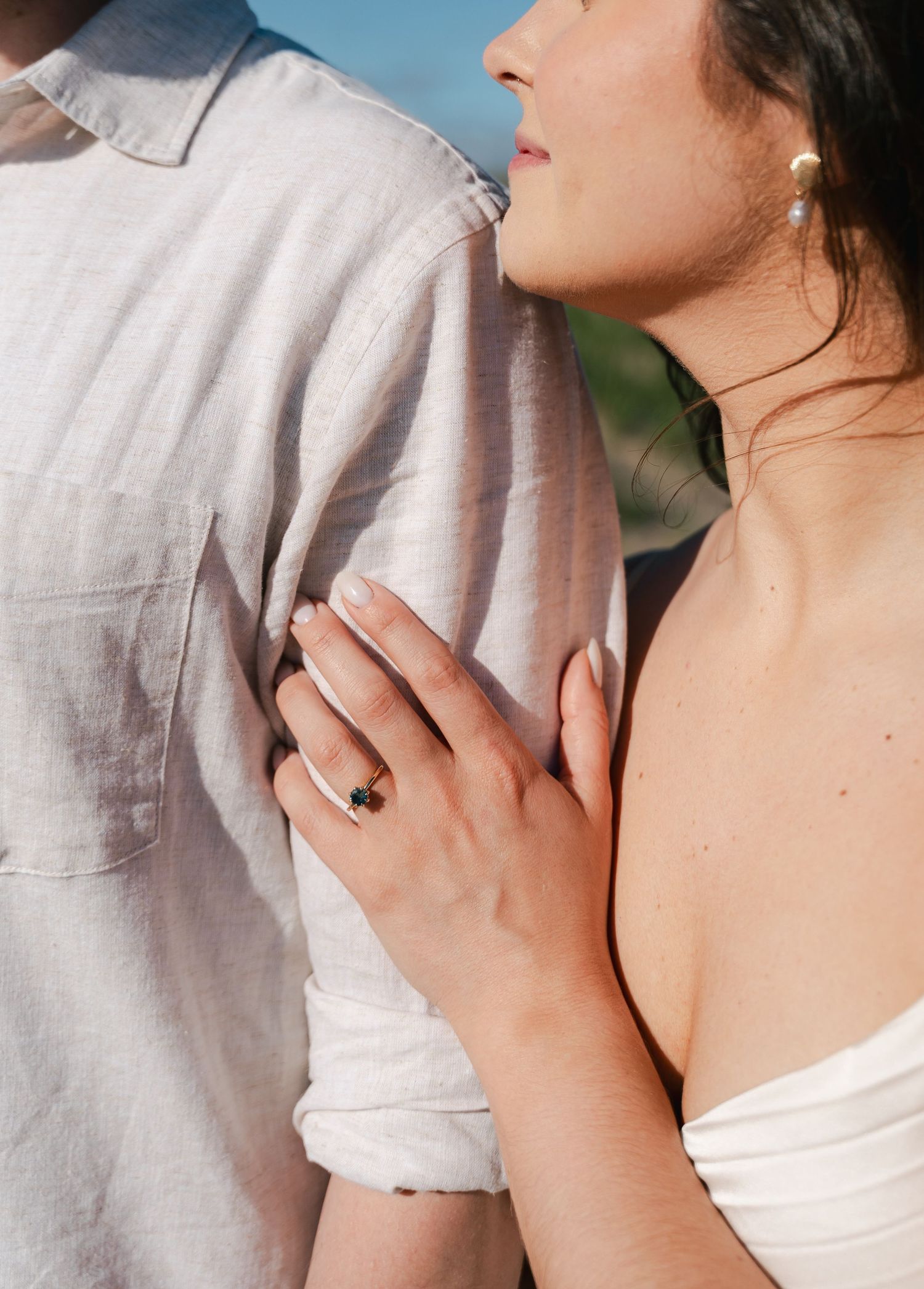 Close-up series showing a person's neck and shoulders wearing a white linen top with delicate hand gestures in Halifax, Nova Scotia.