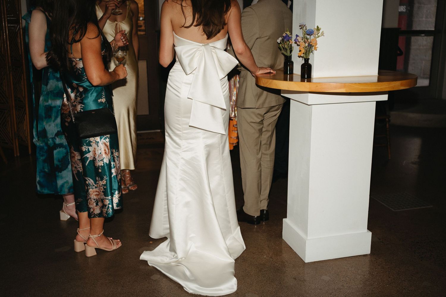 Wedding guests gather around a reception venue with white decor and elegant table settings in Halifax, Nova Scotia..