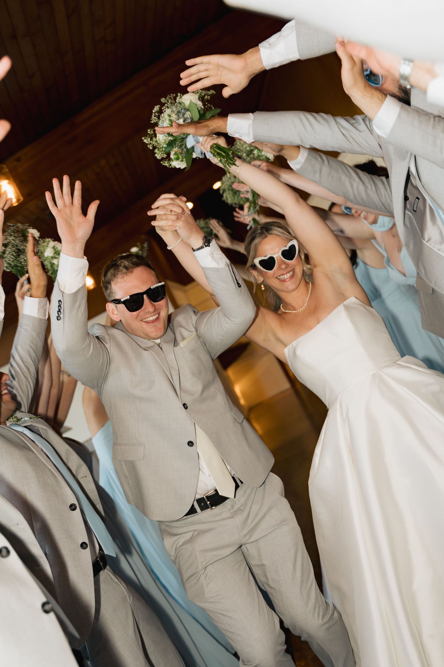 Wedding couple wearing sunglasses dance energetically at their reception celebration in Halifax, Nova Scotia.