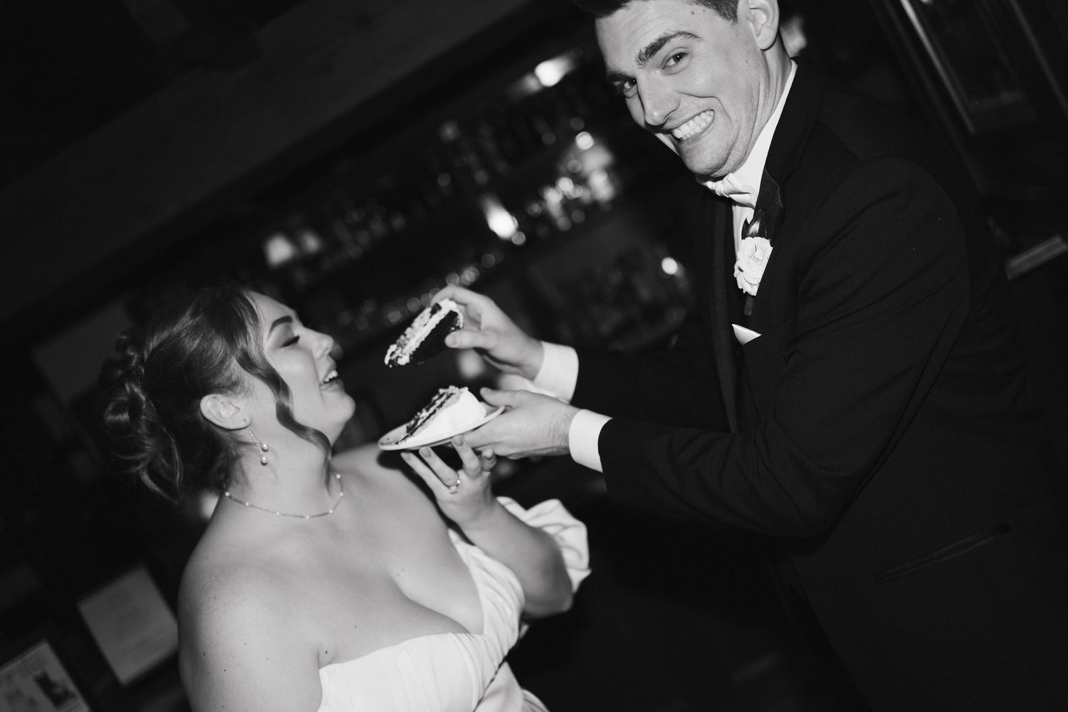 A joyful wedding celebration moment captured in black and white during the cake cutting tradition at Lord Nelson Hotel, Halifax, Nova Scotia