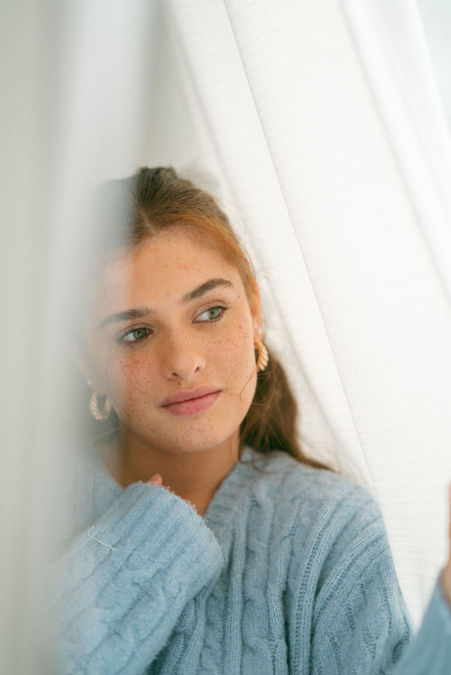 Close-up portrait series featuring a light blue knit sweater against a bright white background in Halifax, Nova Scotia.