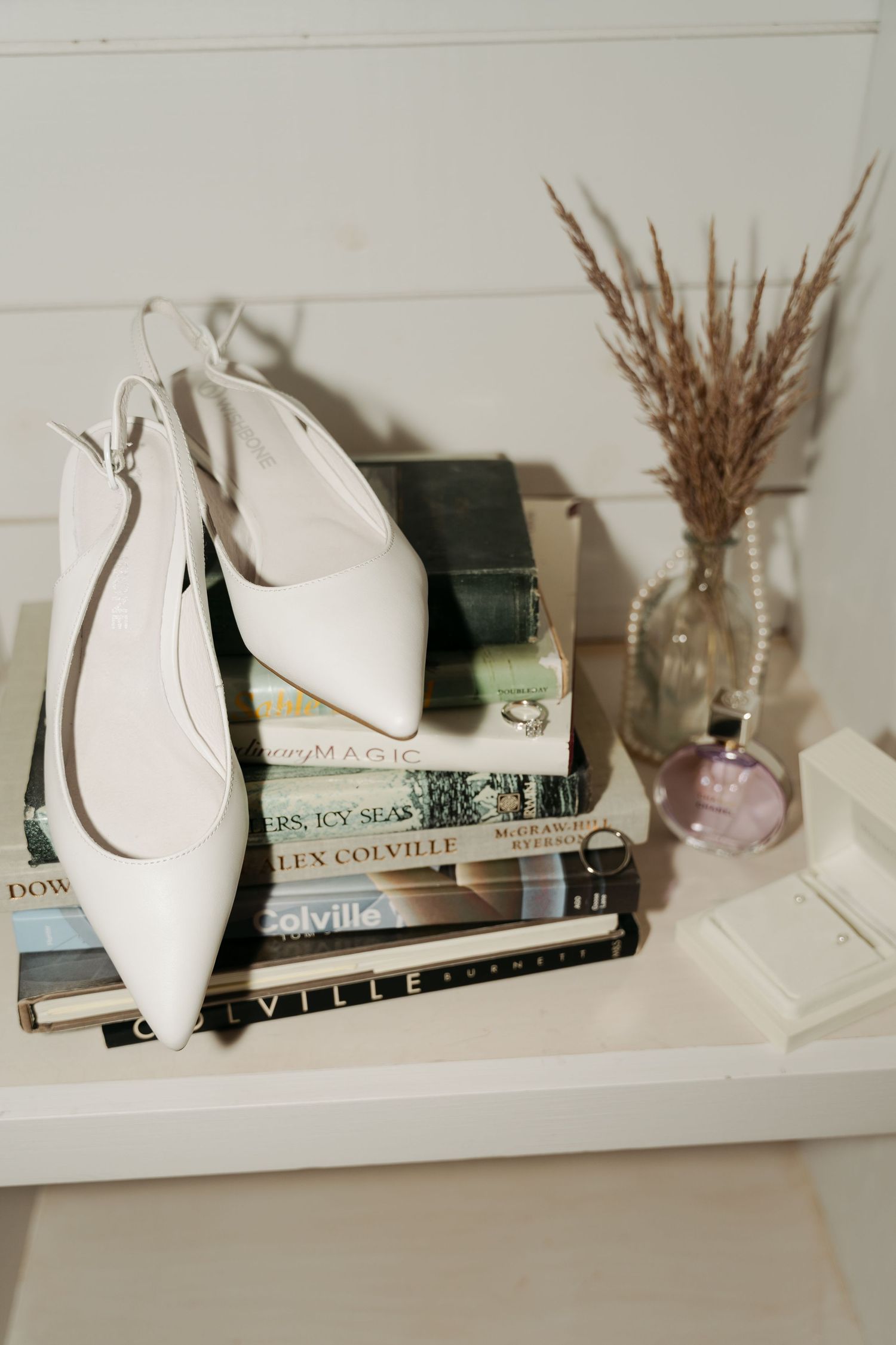 White decorative busts displayed on white shelving with books and dried wheat arrangements at Lightfoot & Wolfville.