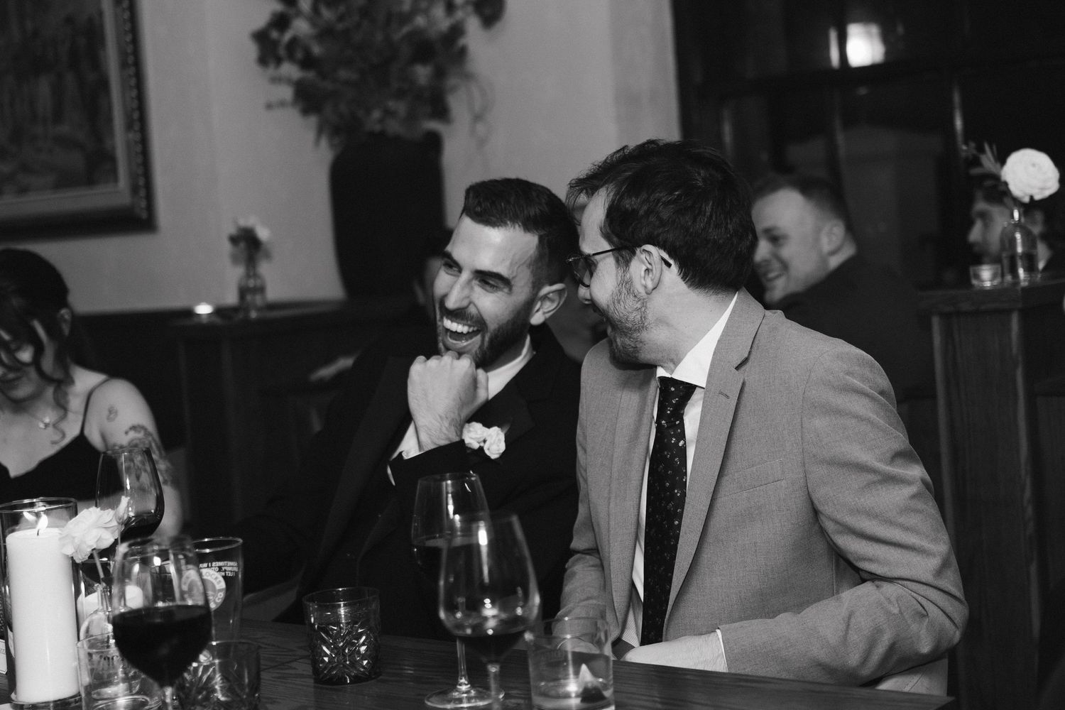 Black and white photograph showing a group of people sitting at a bar counter in what appears to be a social gathering at Lord Nelson Hotel.