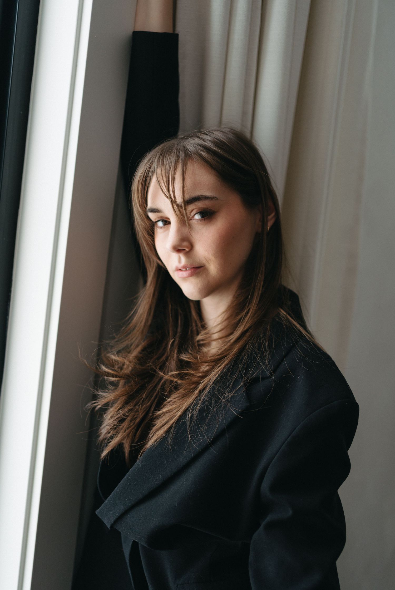 Person wearing black blazer photographed against white curtained window backdrop in Halifax, Nova Scotia.