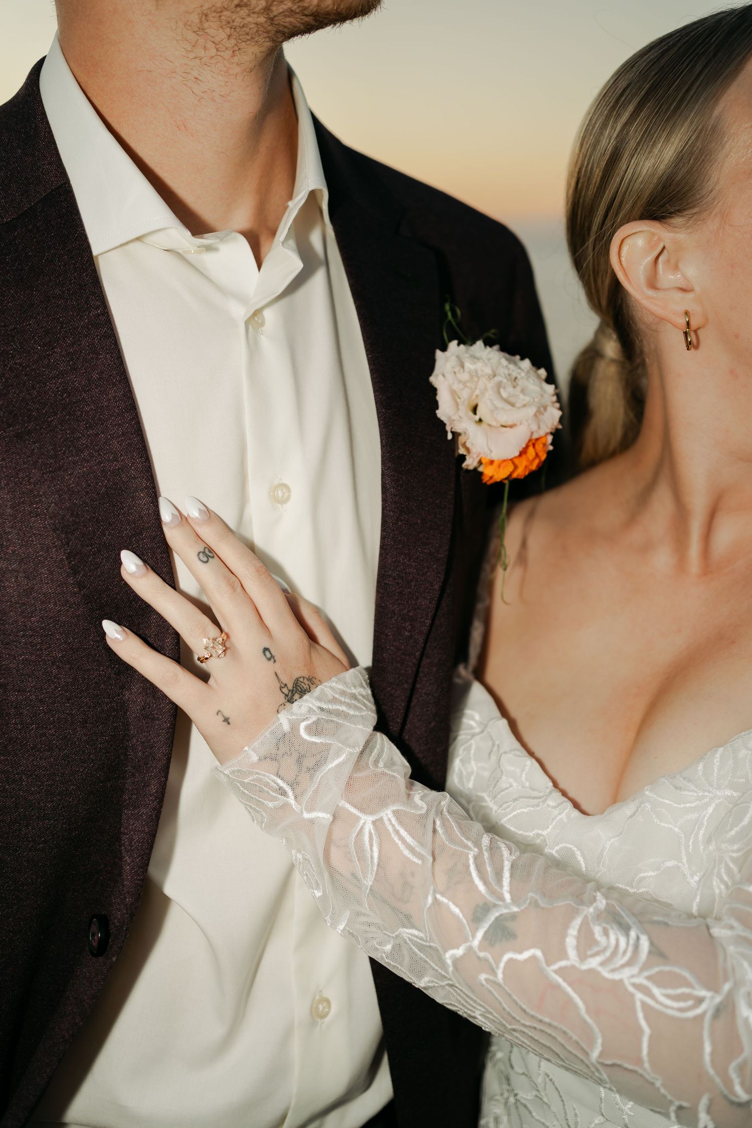 A series of cropped wedding photos showing details of a bride's lace sleeve and groom's suit jacket in Halifax, Nova Scotia.