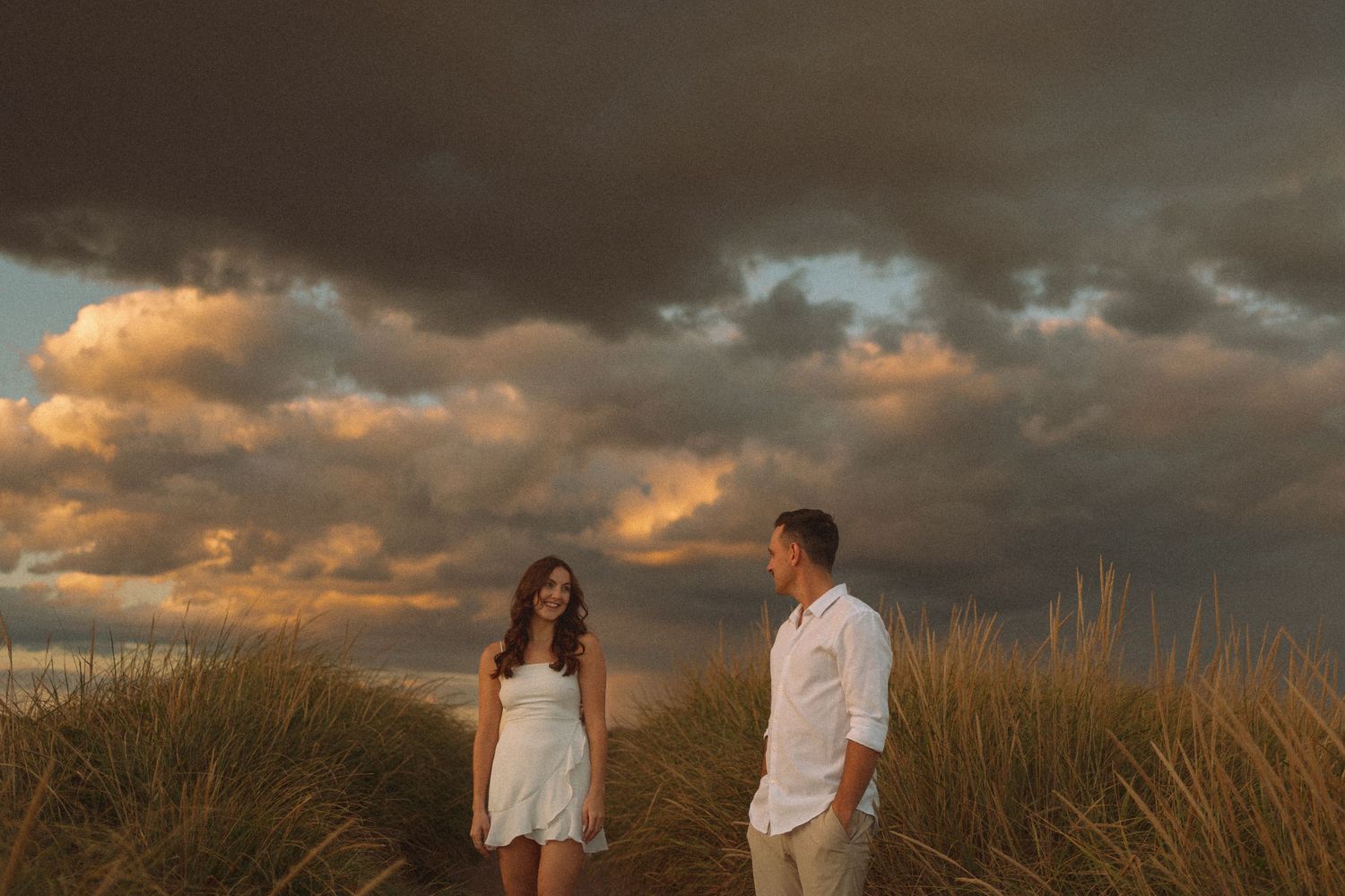 Dramatic sunset clouds over field during wedding photo session in Halifax, Nova Scotia.