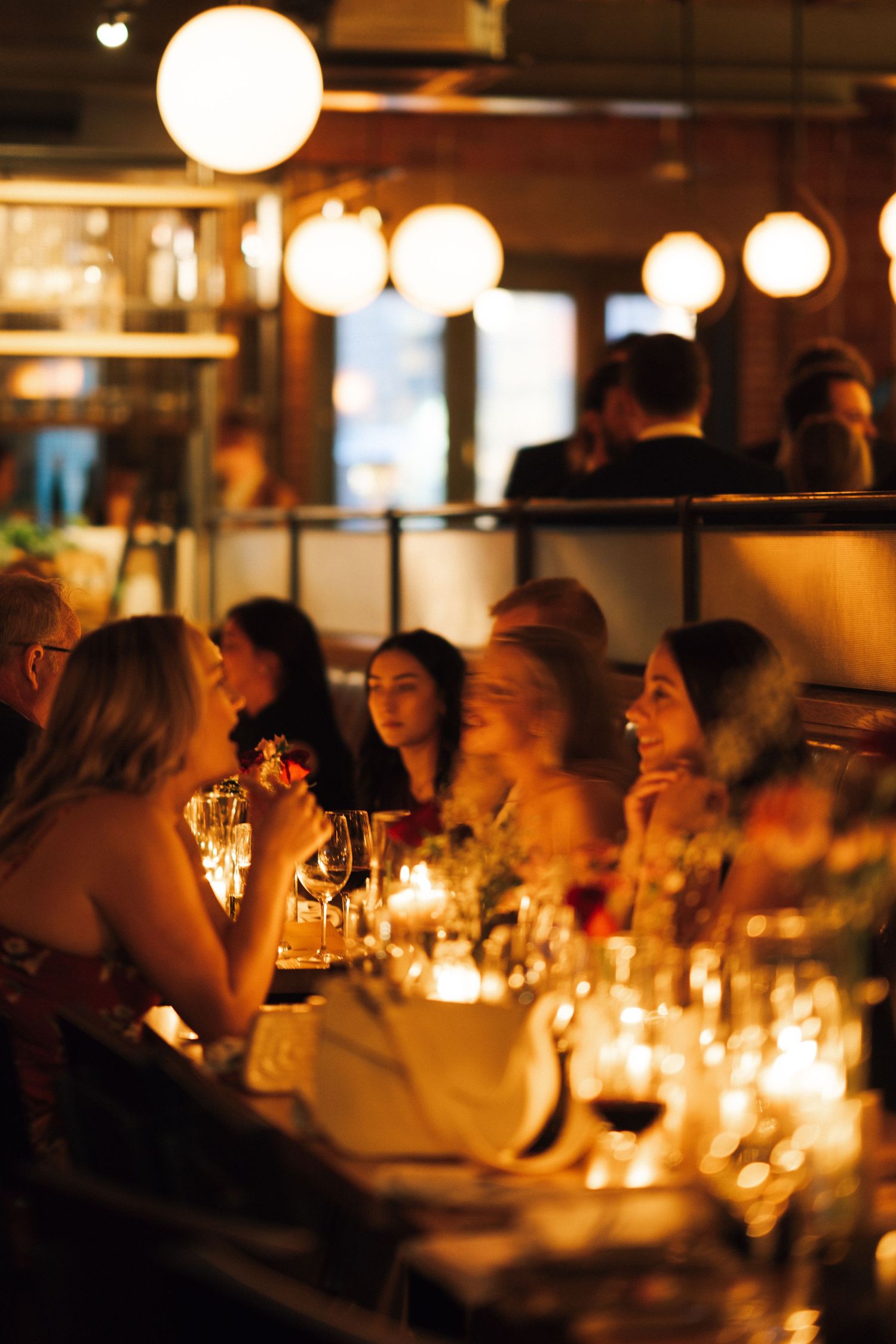 Candlelit restaurant scene showing diners enjoying an intimate dinner in warm ambient lighting in Halifax, Nova Scotia.