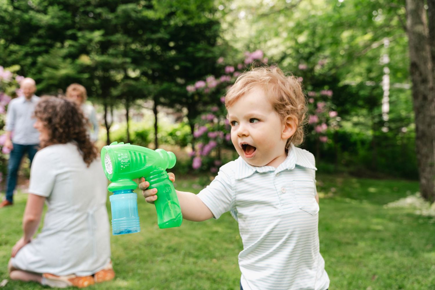 A sequence of five photos showing a child playing with bubbles in a green outdoor setting in Halifax, Nova Scotia.