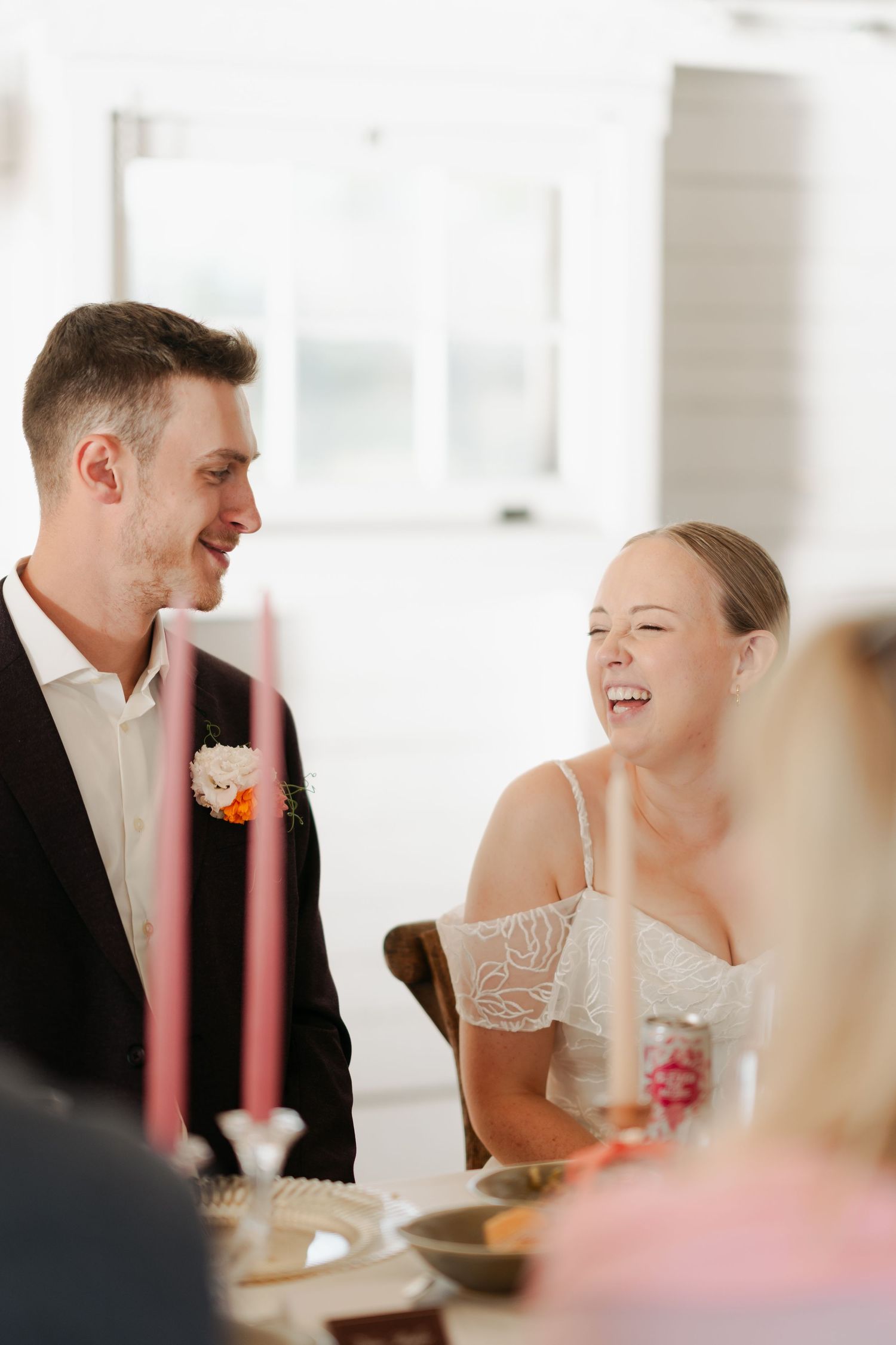Wedding reception scene with guests sharing joyful moments around a dining table in Nova Scotia.