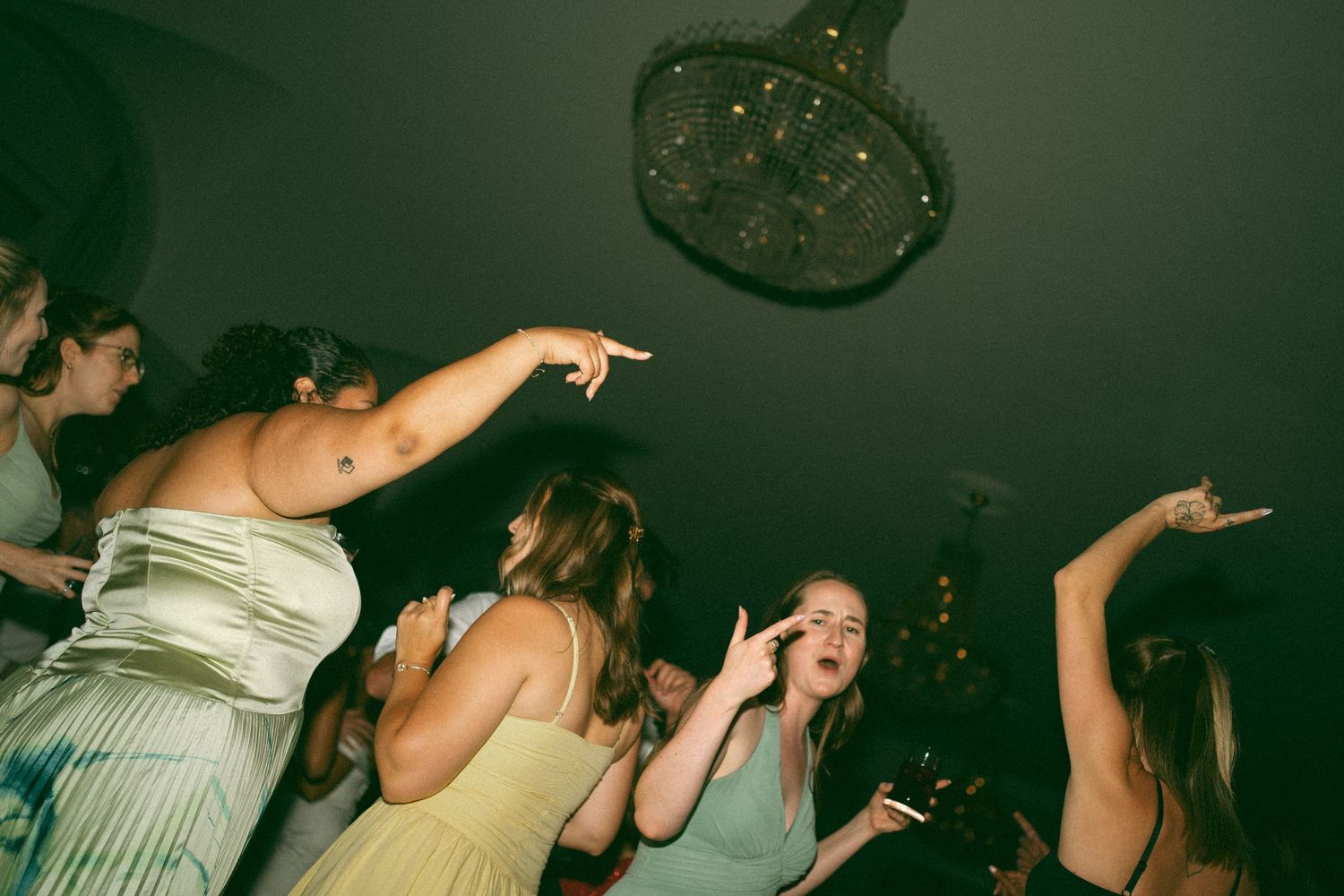 People dancing and celebrating at a dimly lit nightclub or party venue with hands raised in the air in Halifax, Nova Scotia.