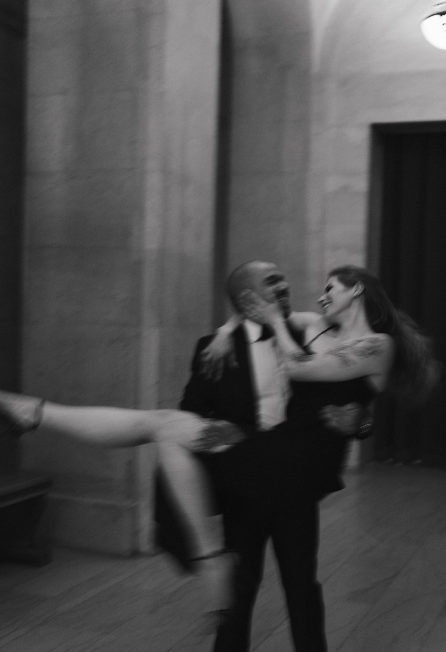 A cinematic blurred black and white photo showing a couple dancing in an elegant venue in Montreal, Quebec for their wedding.