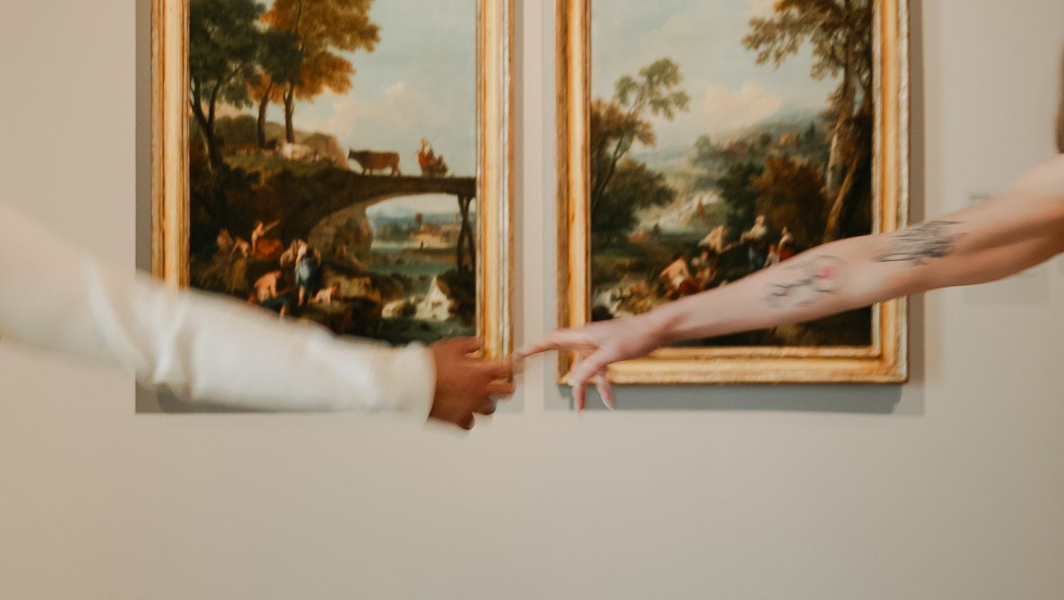 Two hands reaching towards each other against a backdrop of classical landscape paintings, reminiscent of Michelangelo's Creation.