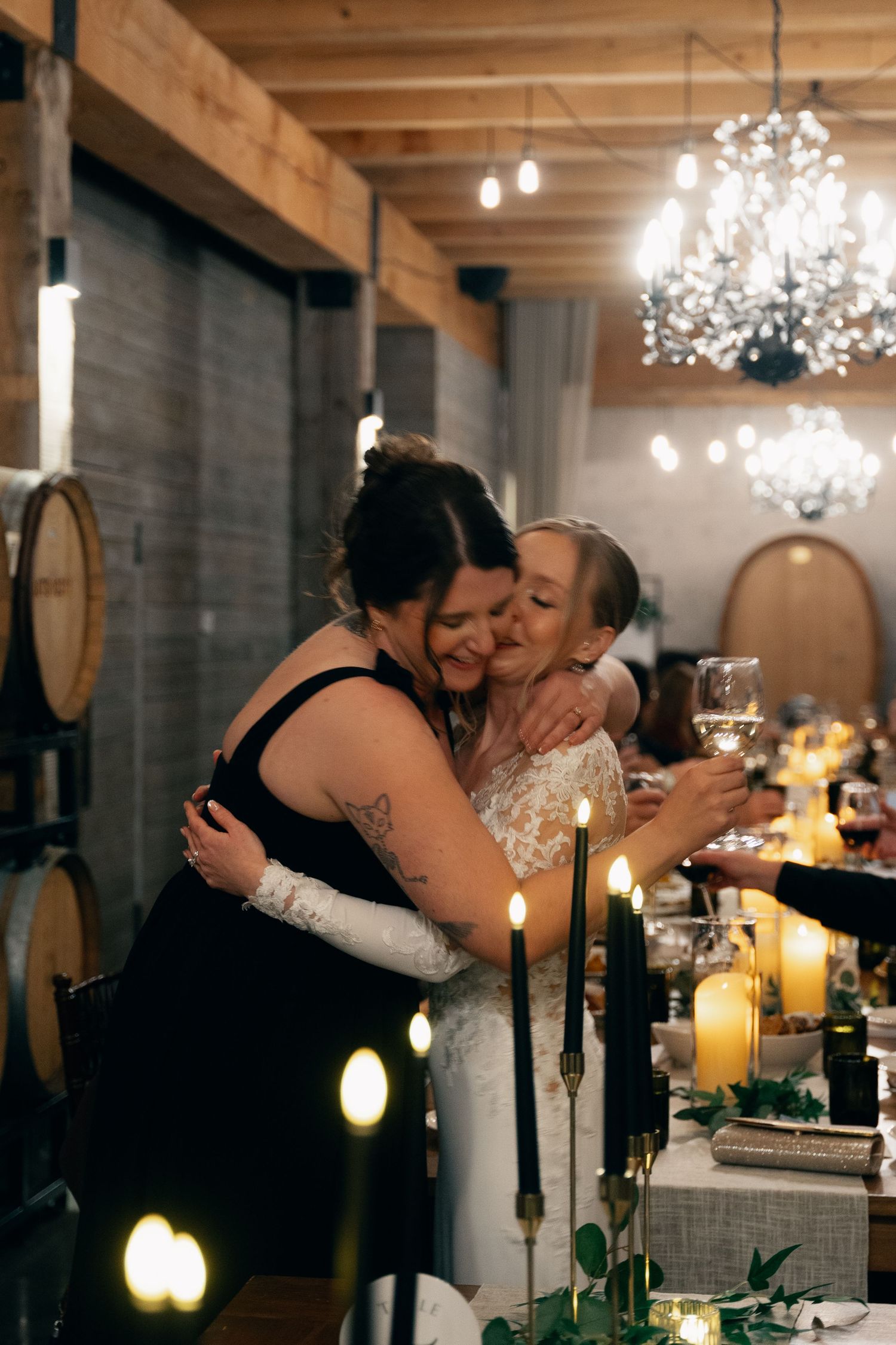 Romantic candlelit reception venue with crystal chandeliers and exposed wooden beams creates an intimate atmosphere at Lightfoot & Wolfville
